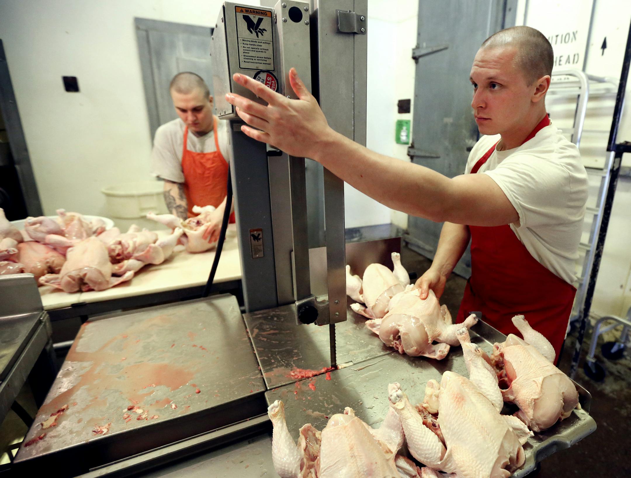 Shawn Wirta, right, and Zach Malich, inmates at the Northeast Regional Corrections Center near Duluth, butchered chickens.