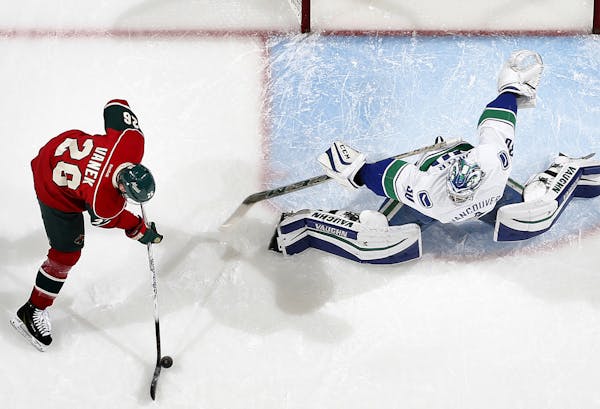 Thomas Vanek prepared to shoot the puck past Canucks goalie Ryan Miller (30) for a goal in the first period.