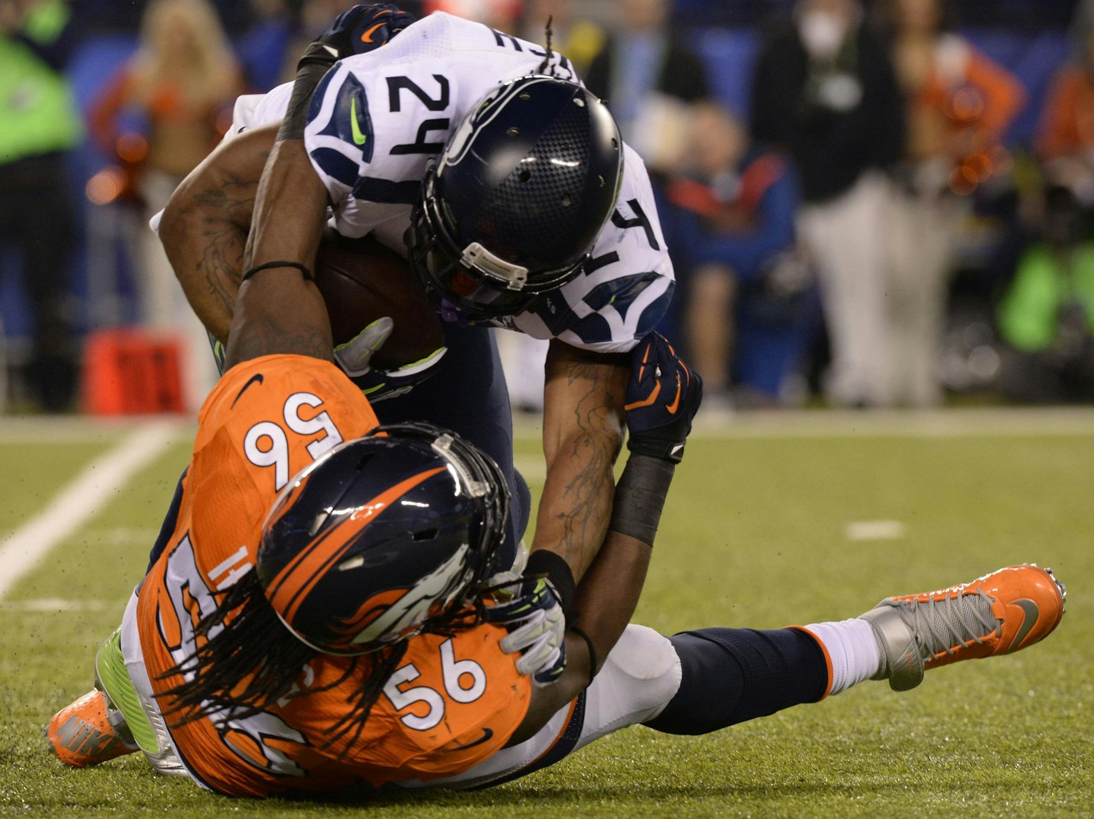 Denver Broncos linebacker Nate Irving (56) brings down Seattle Seahawks running back Marshawn Lynch during the first quarter of Super Bowl XLVIII at MetLife Stadium in East Rutherford, N.J., on Sunday, Feb. 2, 2014. (Christian Murdock/Colorado Springs Gazette/MCT)