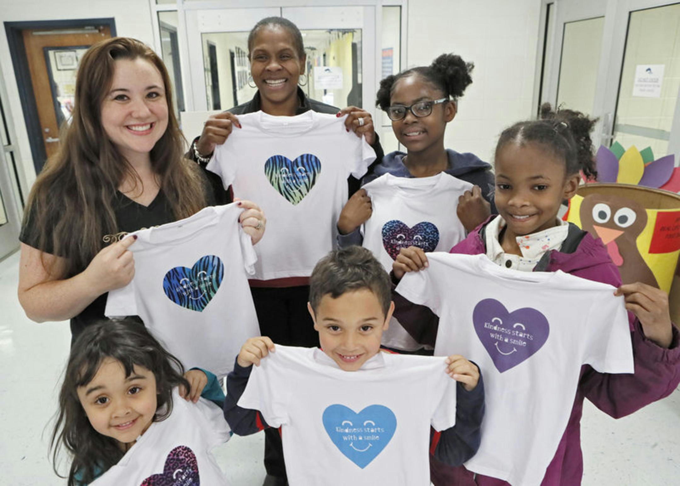 From left, back, Nikki Rajahn, North Fayette Elementary School Principal Lisa Moore, Madison and Morghan Reckley, Brooklyn and Blake Rajahn show off some of the T-shirts. (Bob Andres/Atlanta Journal-Constitution/TNS) ORG XMIT: 1497312