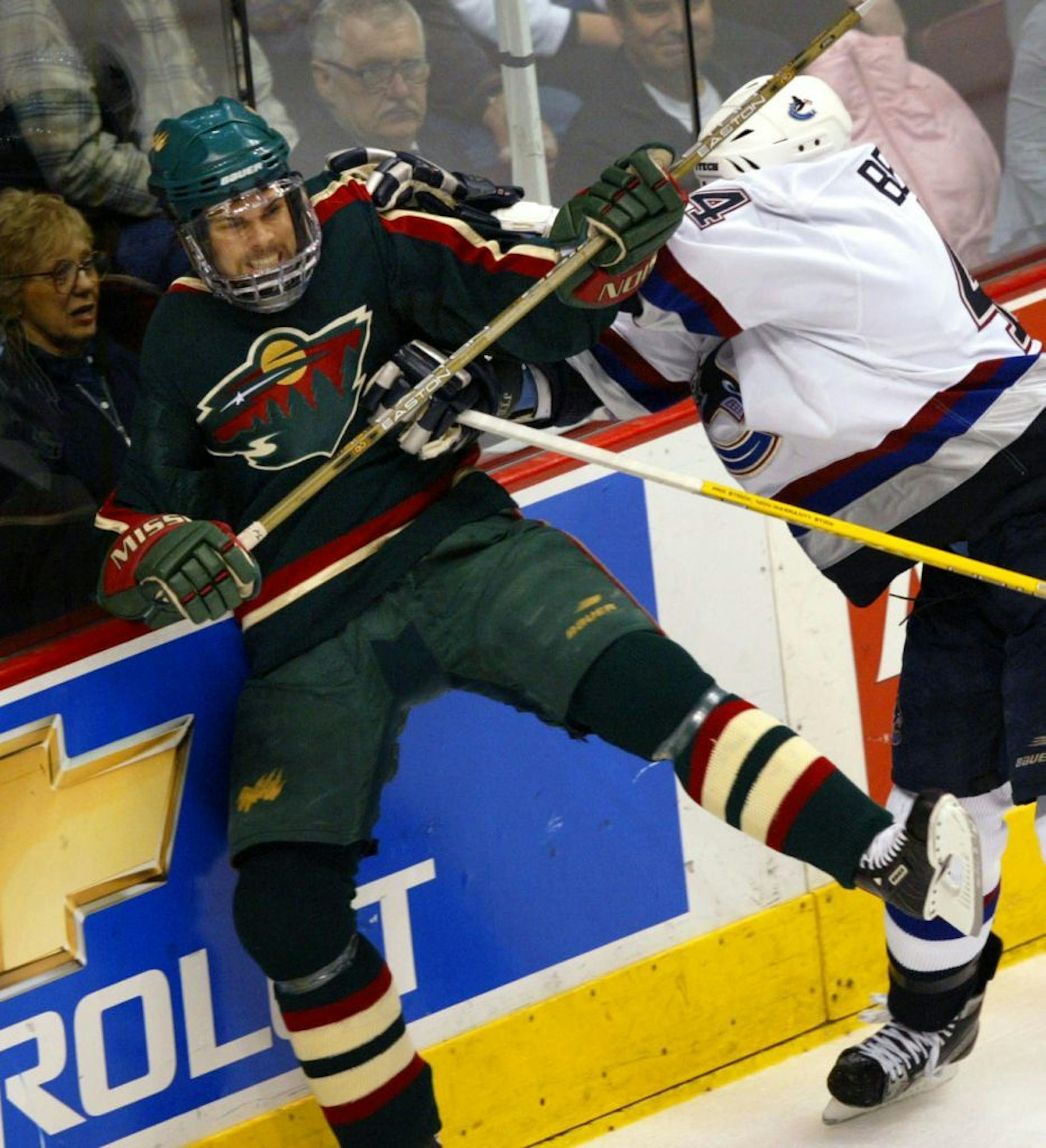 Vancouver, BC 5/5/2003 Minnesota Wild -vs- Vancouver Canucks Game 5 Wild's Willie Mitchell gets checked into the boards by Vancouver's Todd Bertuzzi in the rough first period.