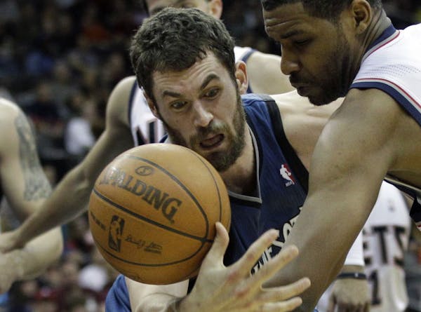 Minnesota Timberwolves Kevin Love, left, grabs for the ball against New Jersey Nets' Shawne Williams, right, during the third quarter of an NBA basket