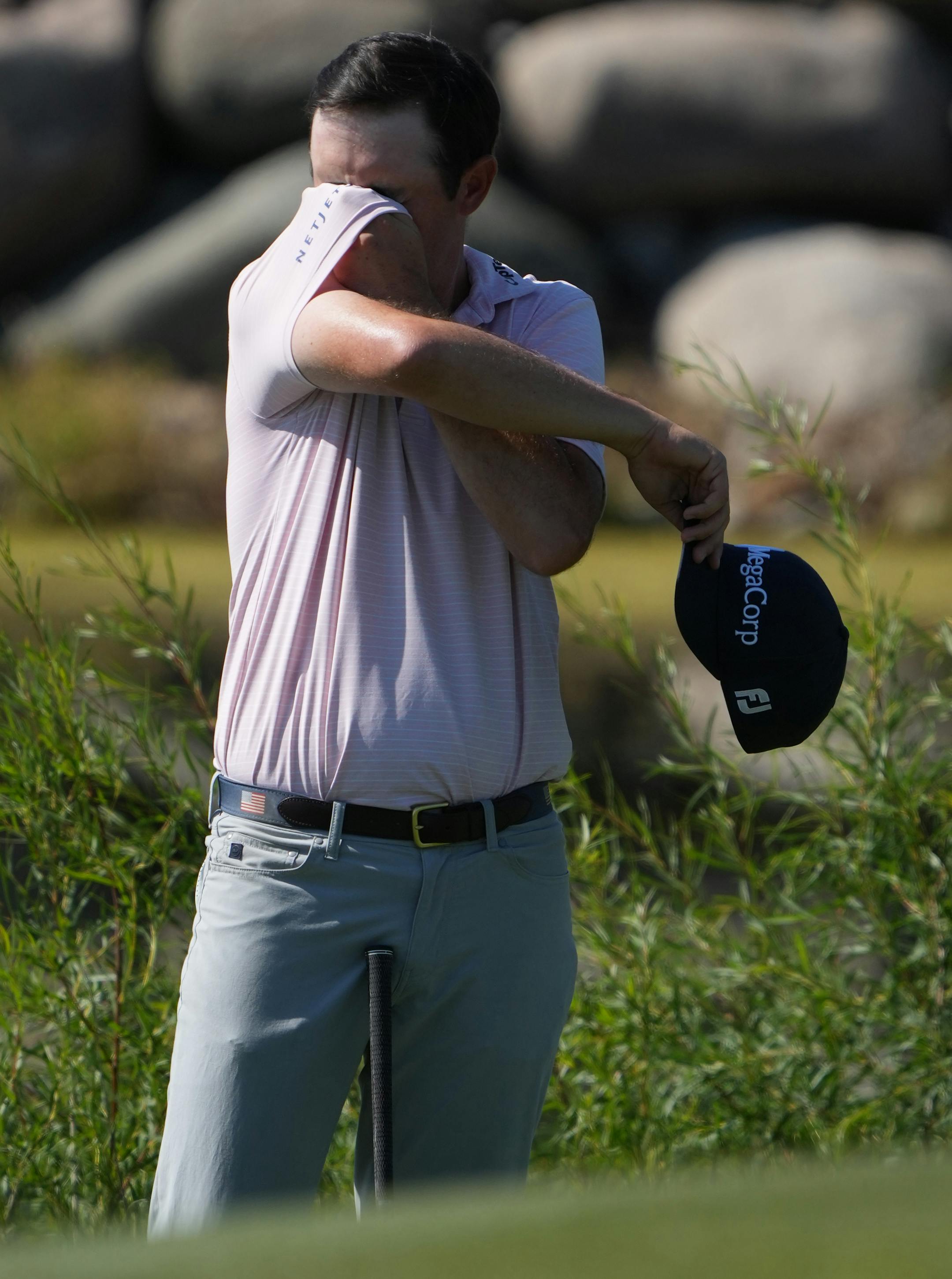 J.T. Poston wipes the sweat off from his face on the 14th hole of the TPC Twin Cities Sunday.