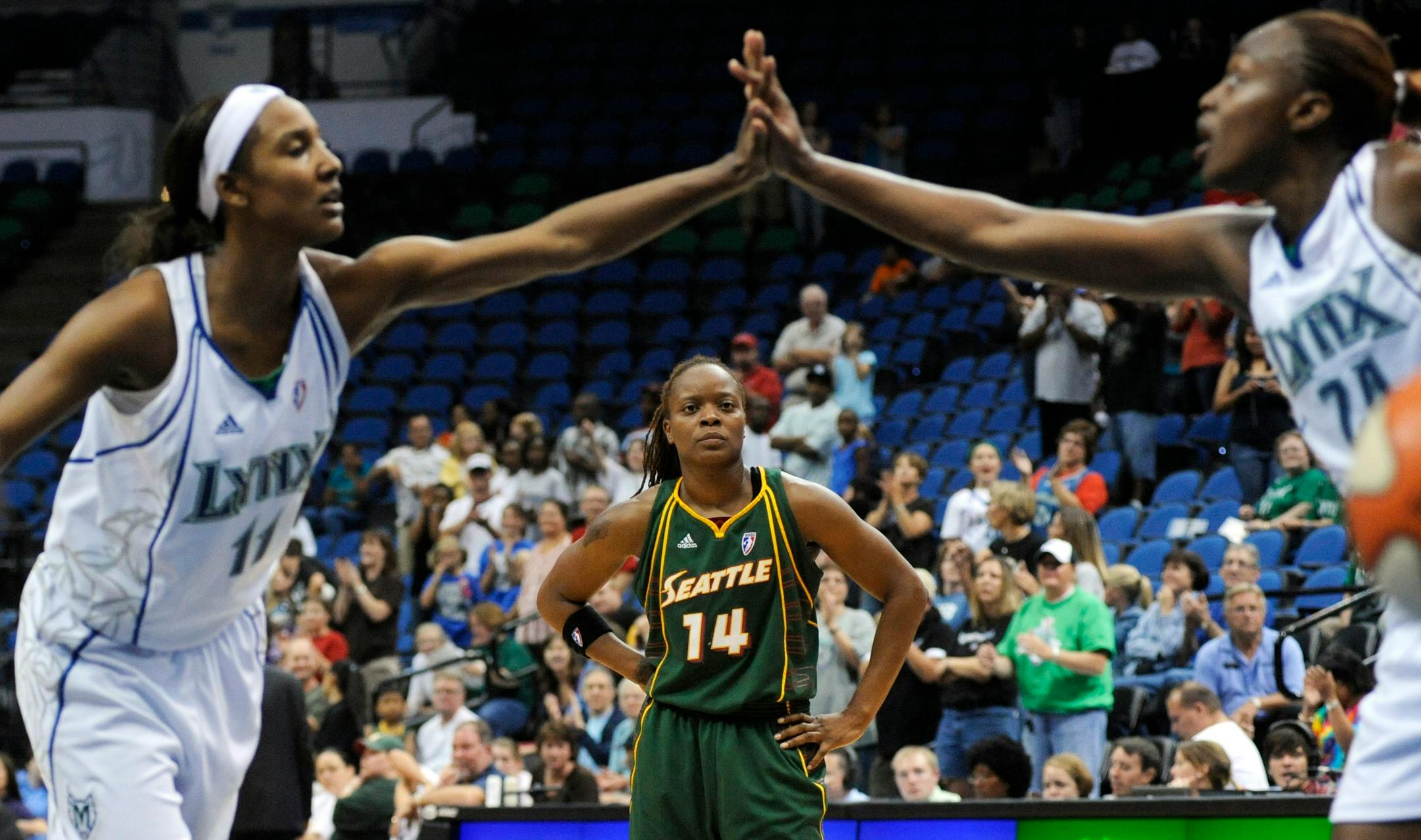 Minnesota Lynx's Candice Wiggins, left, celebrates making a free throw with Charde Houston, right, in the final minute as Seattle Storm's Shannon Johnson (14) looks on during a WNBA basketball game in Minneapolis on Saturday, Sept. 5, 2009. Minnesota defeated Seattle 76-68. (AP Photo/Hannah Foslien)