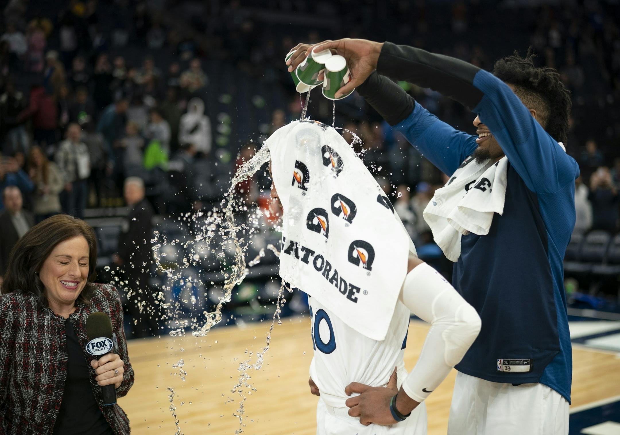 Minnesota Timberwolves forward Robert Covington (33) gave teammate Minnesota Timberwolves guard Josh Okogie a mini-Gatorade shower while he was interviewed by Fox Sports North's Marney Gellner after the game.