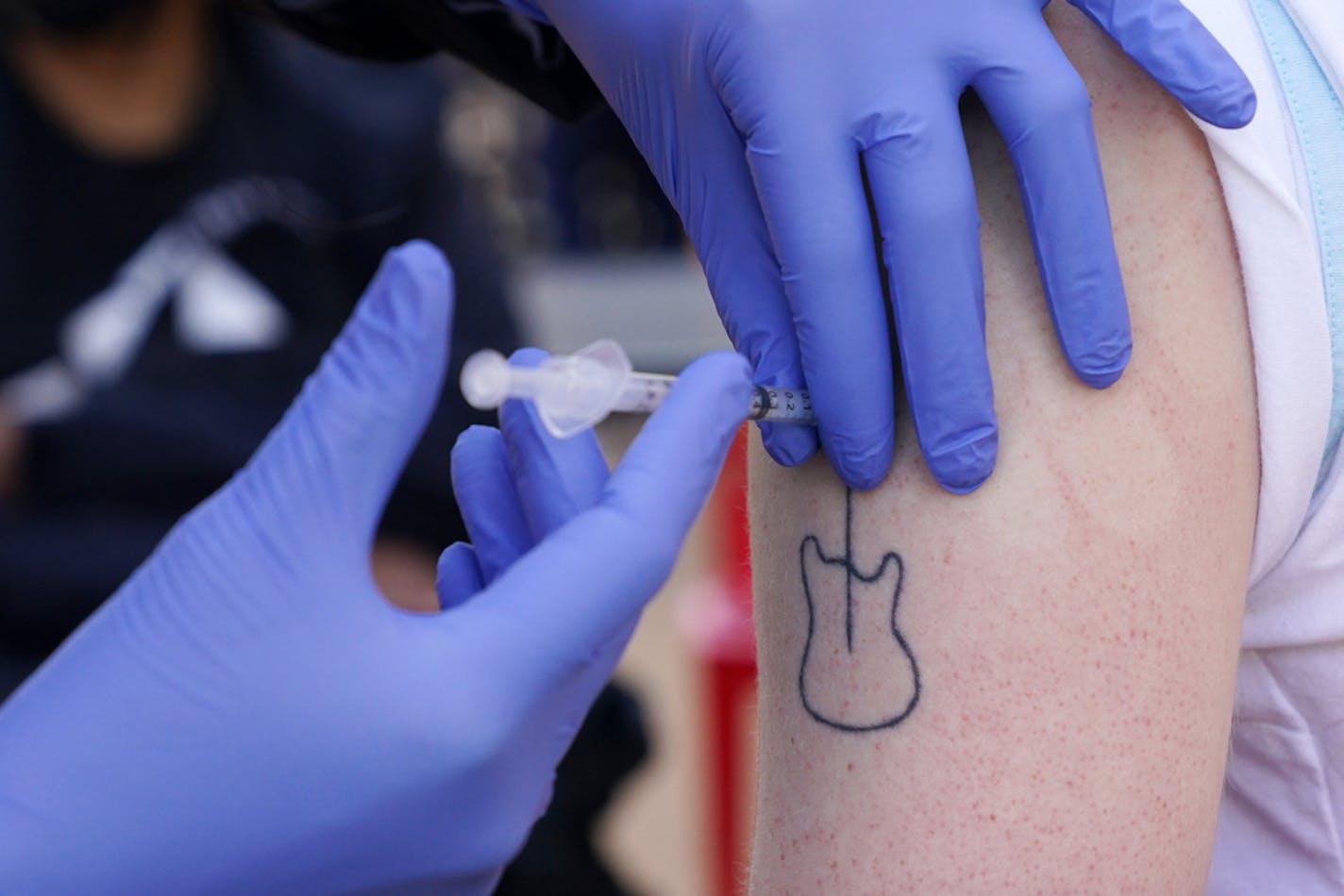 Jackson Thellin, a cashier at Broders' Pasta Bar, got the second dose of the Pfizer COVID-19 vaccine from Dr. Abby Houts at a clinic set up for employees. ] ANTHONY SOUFFLE • anthony.souffle@startribune.com