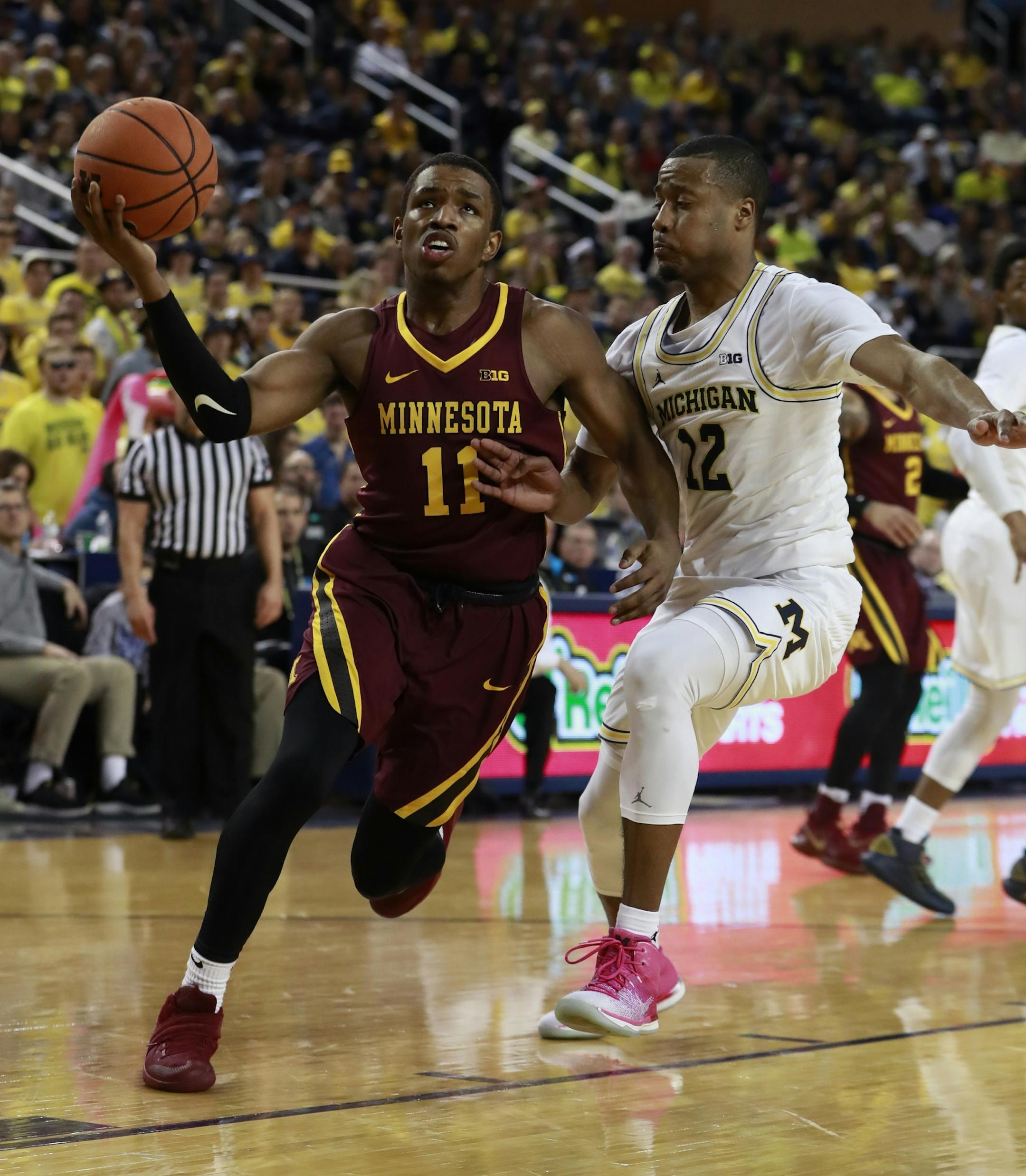 Minnesota guard Isaiah Washington (11) drives to the basket as Michigan guard Muhammad-Ali Abdur-Rahkman (12) defends during the first half of an NCAA college basketball game, Saturday, Feb. 3,2018, in Ann Arbor, Mich. (AP Photo/Carlos Osorio) ORG XMIT: MIN2018020520323839