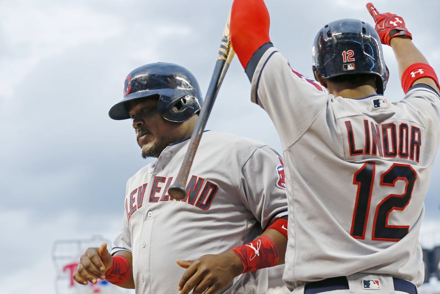 Cleveland Indians' Juan Uribe , left, is congratulated by Francisco Lindor after he scored on a two-run double by Carlos Santana off Minnesota Twins pitcher Tyler Duffey in the fifth inning of a baseball game Saturday, July 16, 2016, in Minneapolis.