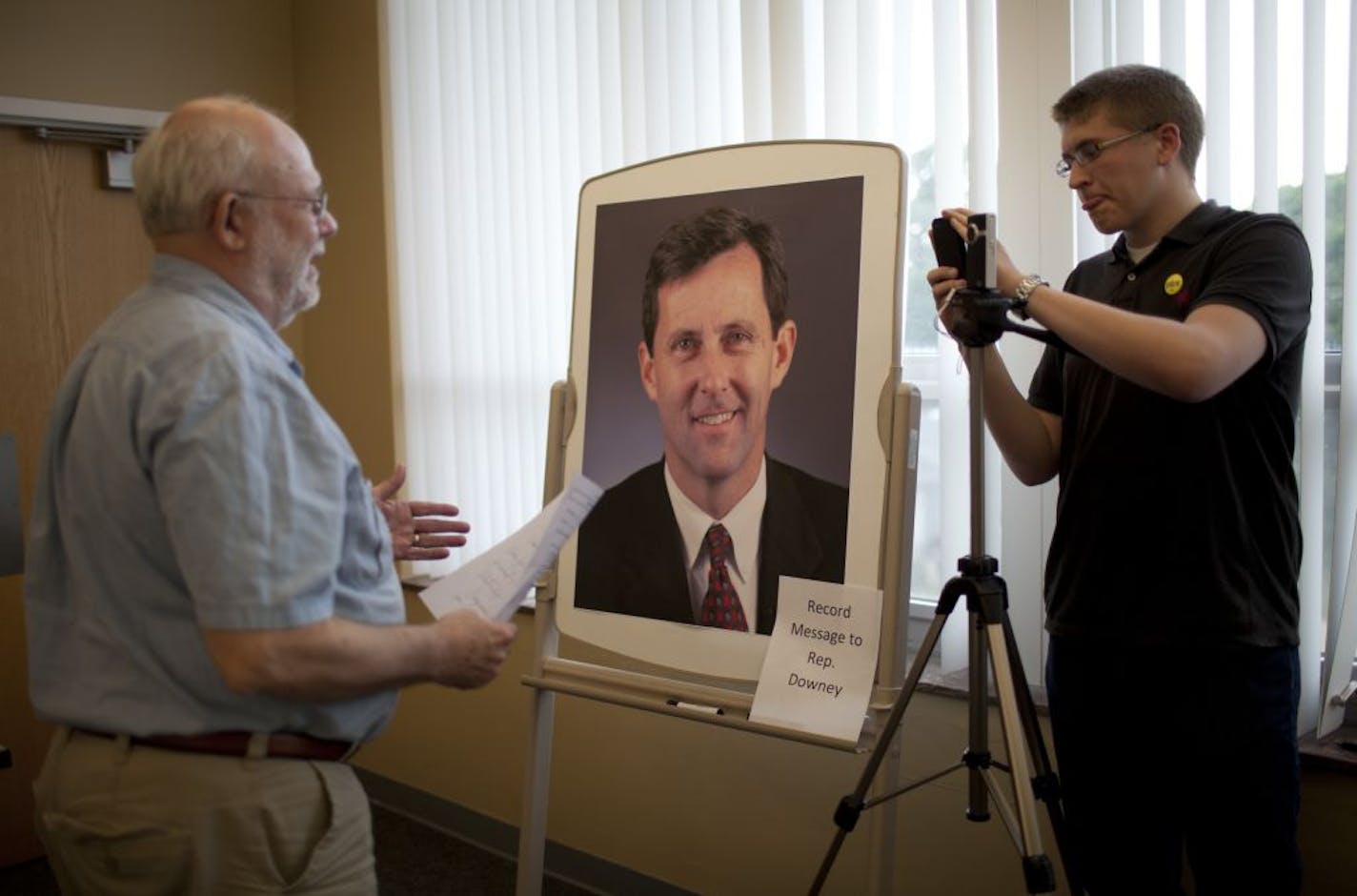 John Knoll of Edina, left, made a video statement calling for his state representative, Keith Downey, to show some leadership on the state government shutdown Thursday evening, July 7, 2011 at the Edina Community Center in Edina, Minn. Thomas Trehus was operating the video camera for the statements, which will be delivered to Rep. Downey. The Minneapolis Regional Labor Federation hosted a community meeting to discuss the current state government shutdown at the Edina Community Center and said th