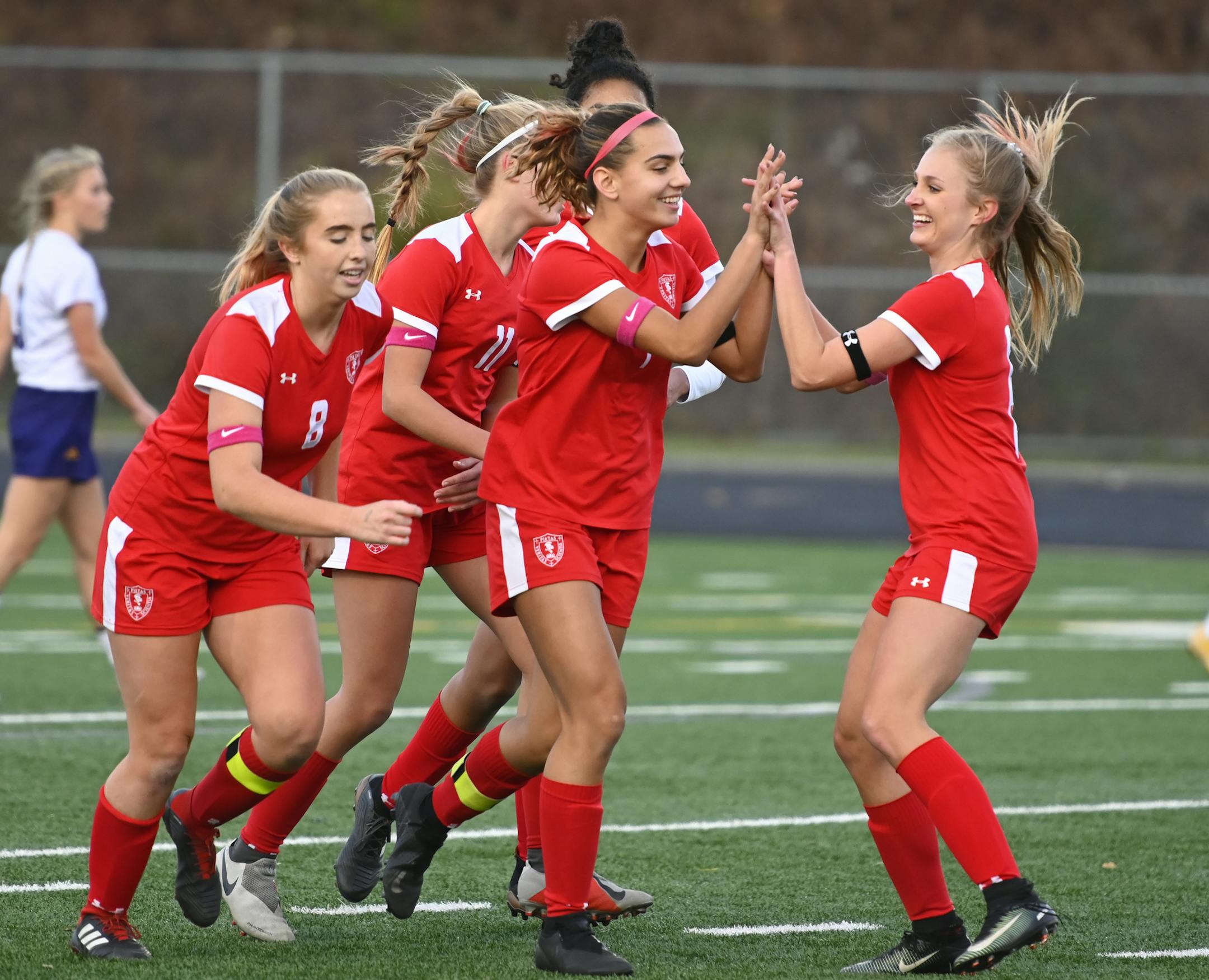 Teammates celebrated with Benilde-St. Margaret's midfielder Amanda Cassidy (7), center, after she scored a goal in the first half against Rochester Lourdes. ] Aaron Lavinsky • aaron.lavinsky@startribune.com Benilde-St. Margaret's played Rochester Lourdes in a Class 1A girls' quarterfinal game on Wednesday, Oct. 24, 2018 at Prior Lake High School in Savage, Minn.