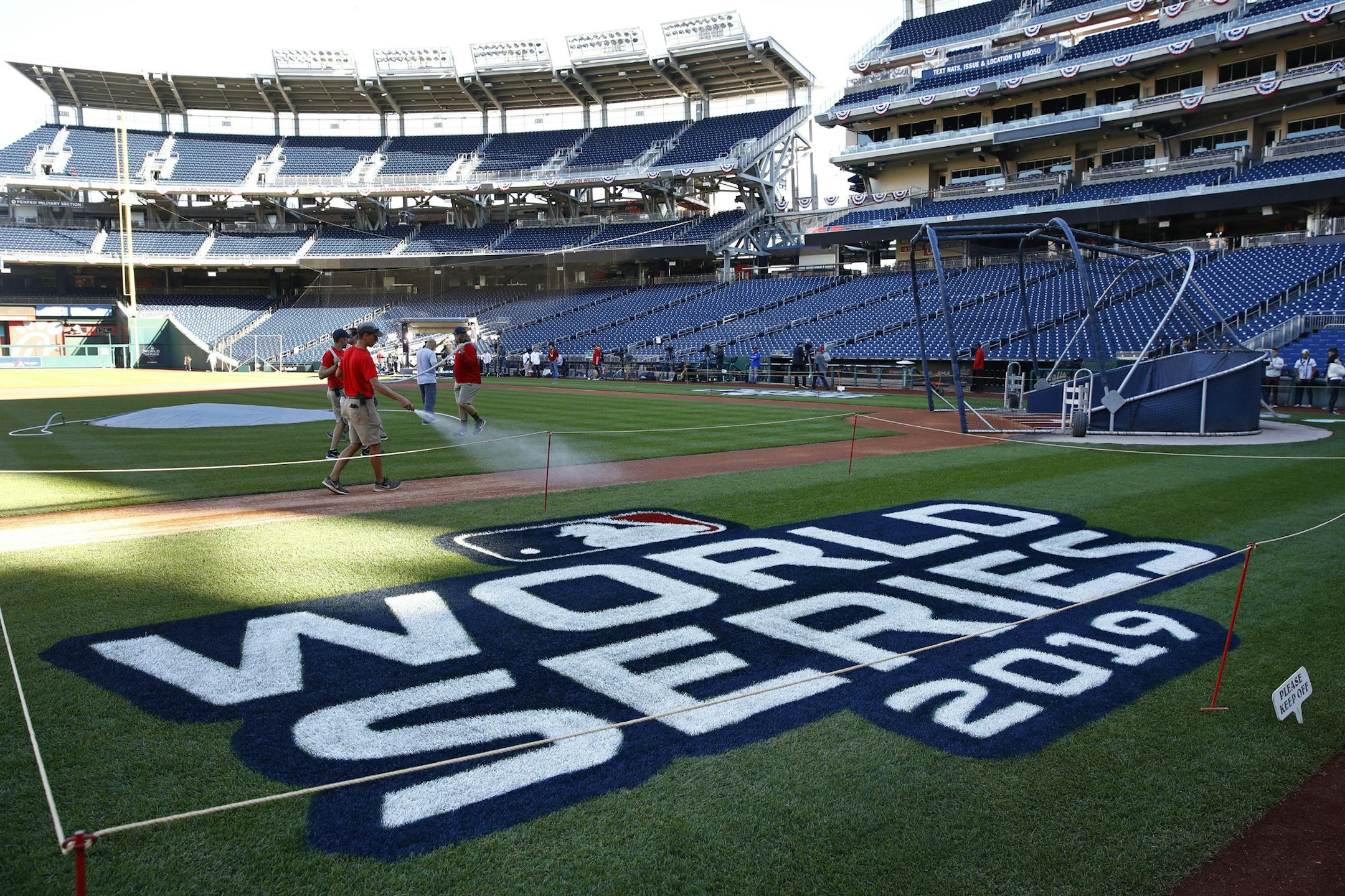 Groundskeepers prepare the infield for batting practice at Nationals Park in Washington, Thursday, Oct. 24, 2019. The Houston Astros and Washington Nationals are scheduled to play Game 3 of baseball's World Series on Friday, Oct. 25. (AP Photo/Patrick Semansky)