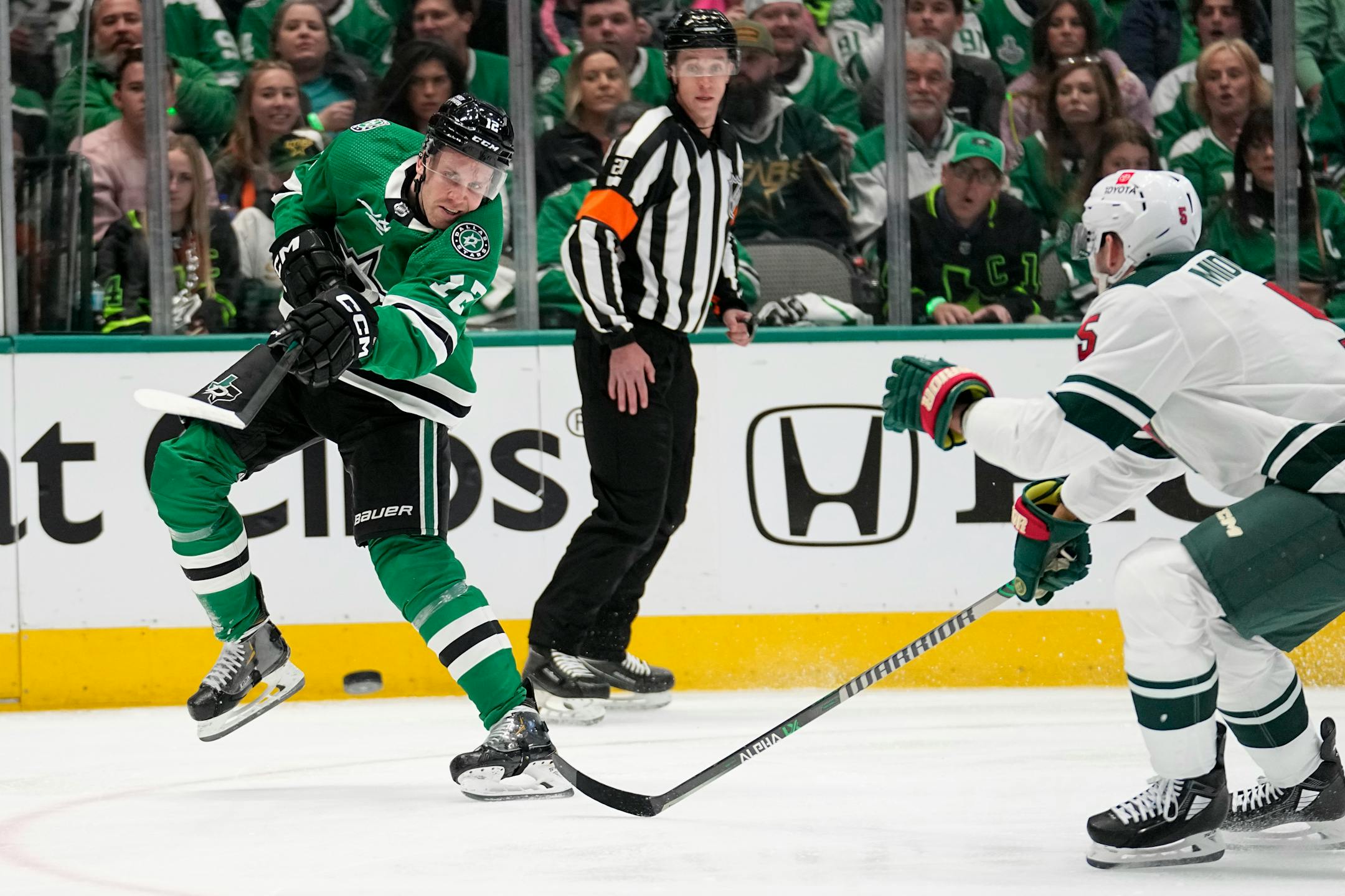 Dallas Stars center Radek Faksa (12) shoots as Minnesota Wild defenseman Jake Middleton (5) defends in the first period of Game 1.