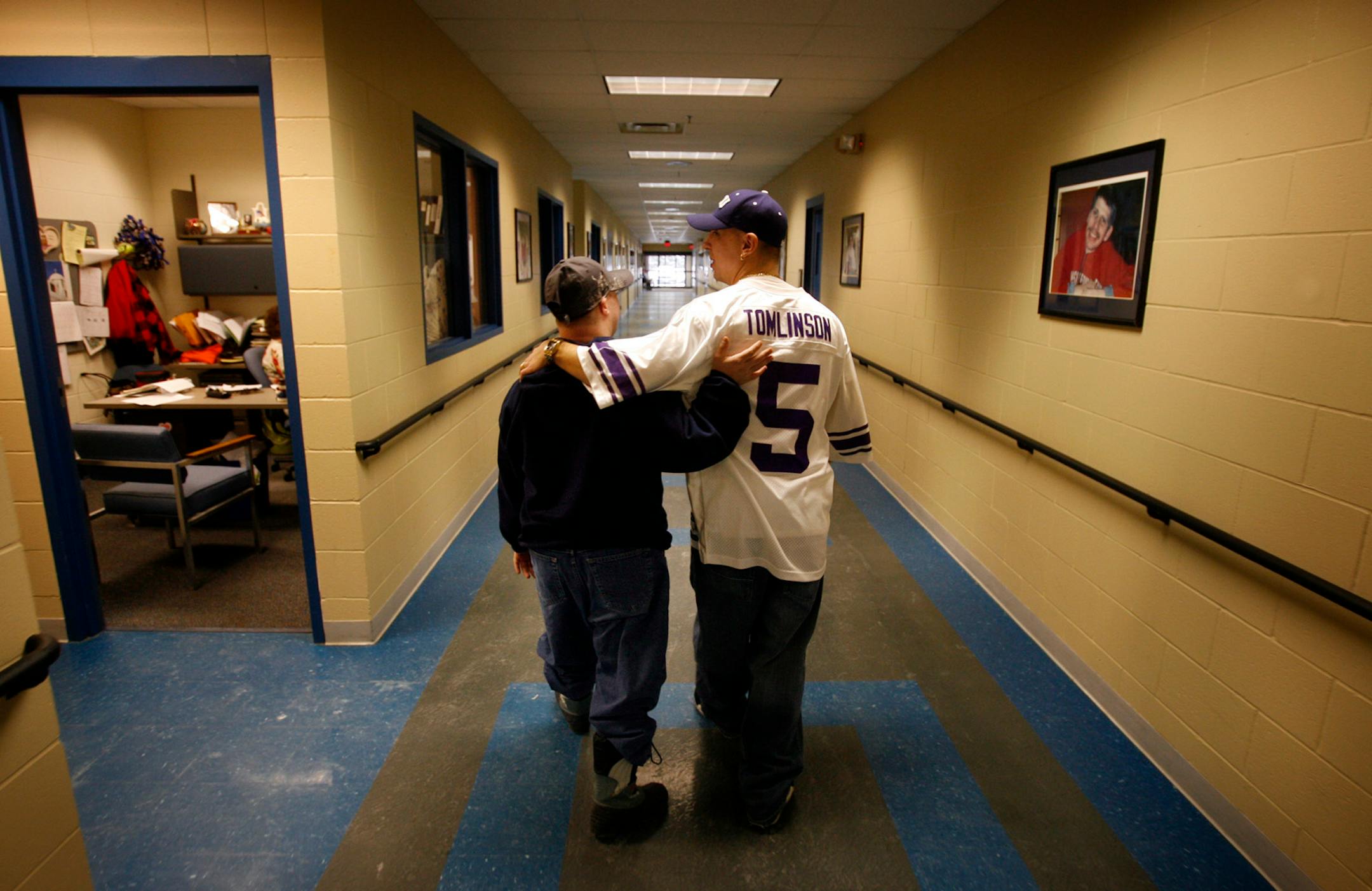 David Mohler, left, a client at Achieve Services Inc., walks with Cory Maggiolo, who runs the program with wife Kelly, as they head to the work room to retreive Mohler's paycheck. Achieve Services provides work and training for adults with developmental disabilities in Anoka County to improve clients' options for living.