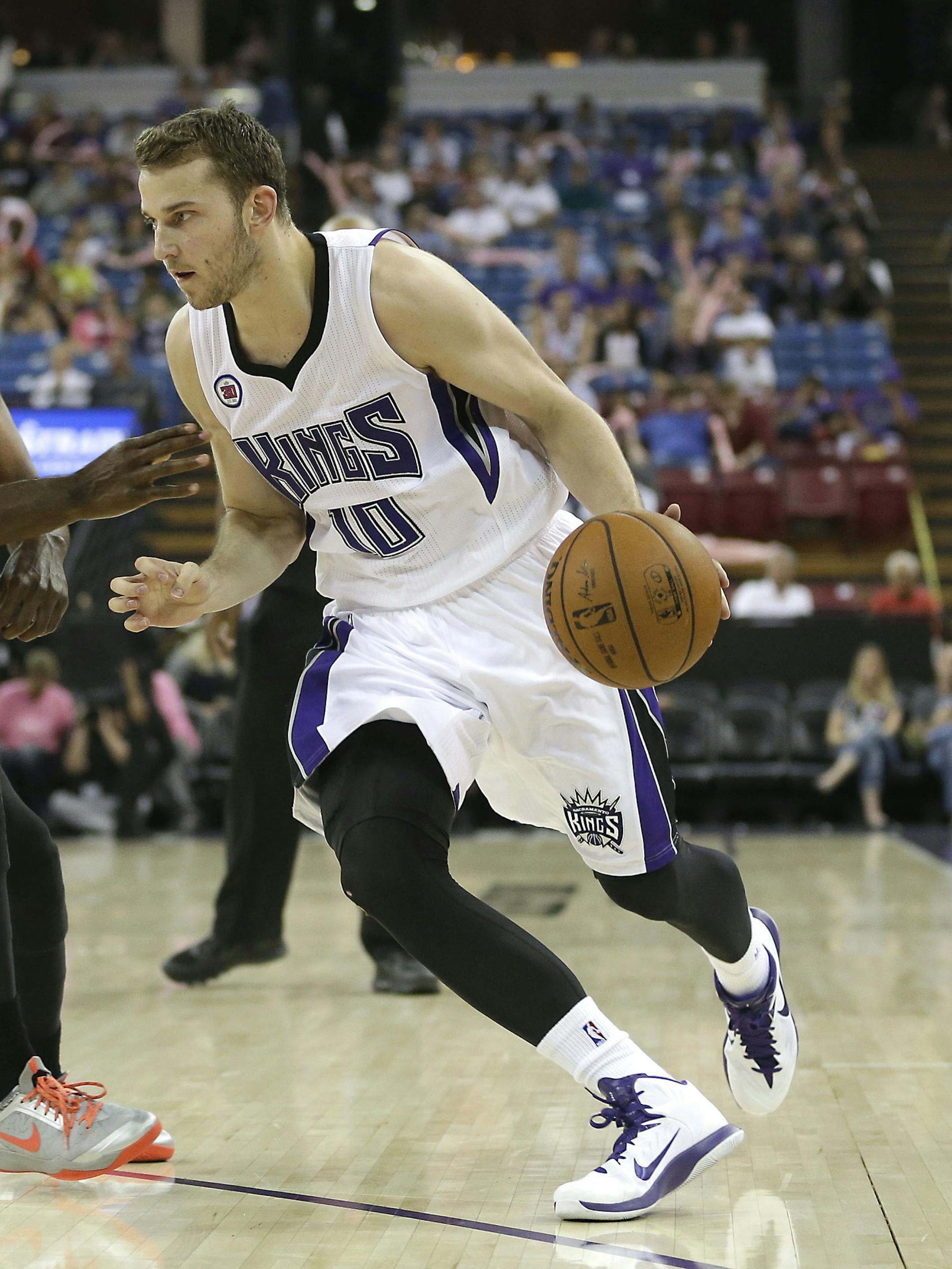 Sacramento Kings guard Nik Stauskas, of Canada, right, drives against Toronto Raptors forward Jordan Hamilton during the fourth quarter of an NBA preseason basketball game in Sacramento, Calif., Tuesday, Oct. 7, 2014. The Kings won 113-106. (AP Photo/Rich Pedroncelli) ORG XMIT: SCA109