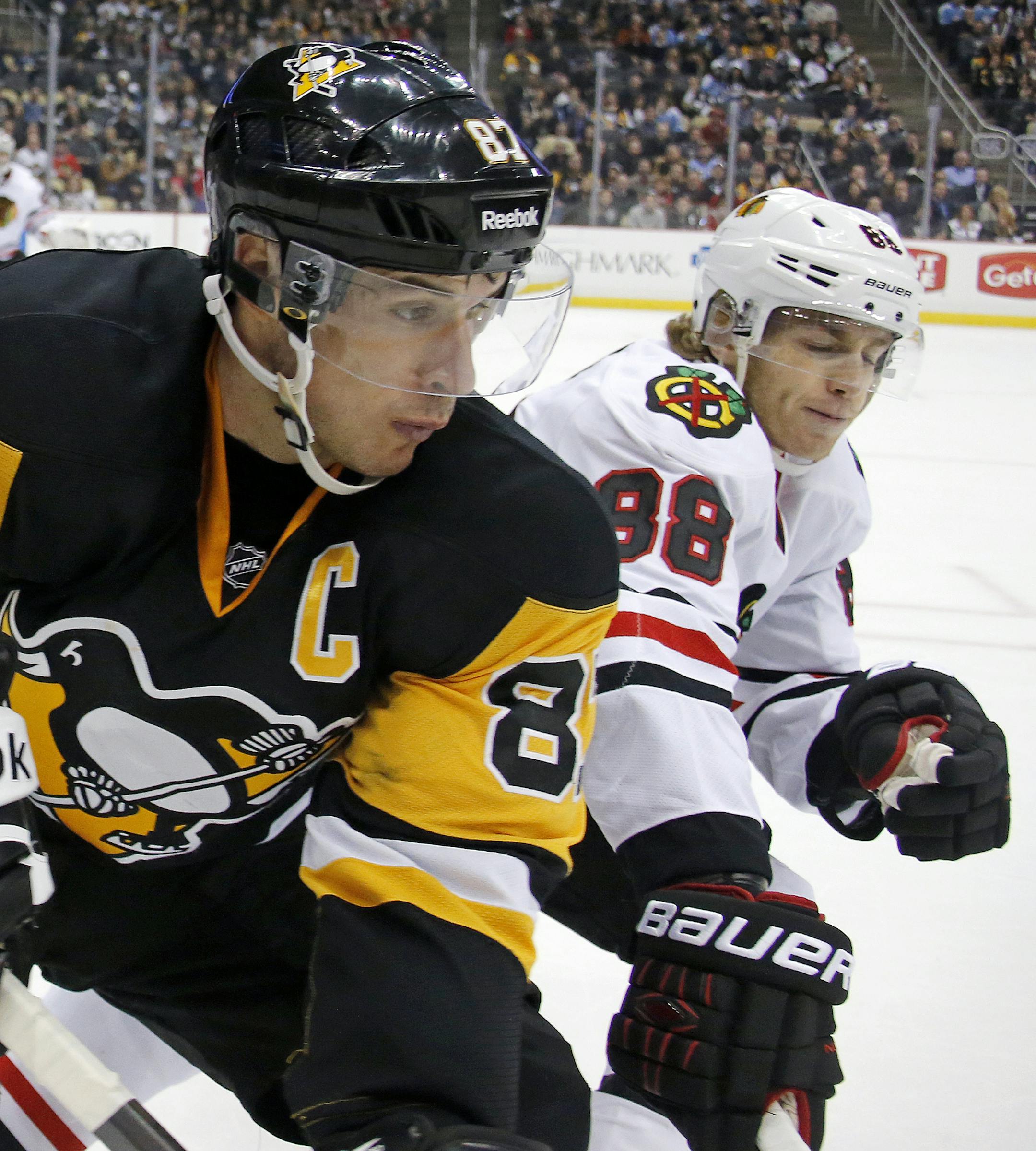 Pittsburgh Penguins' Sidney Crosby (87) works the puck in the corner against Chicago Blackhawks' Patrick Kane (88) during the second period of an NHL hockey game in Pittsburgh Wednesday, Jan. 21, 2015.(AP Photo/Gene J. Puskar)
