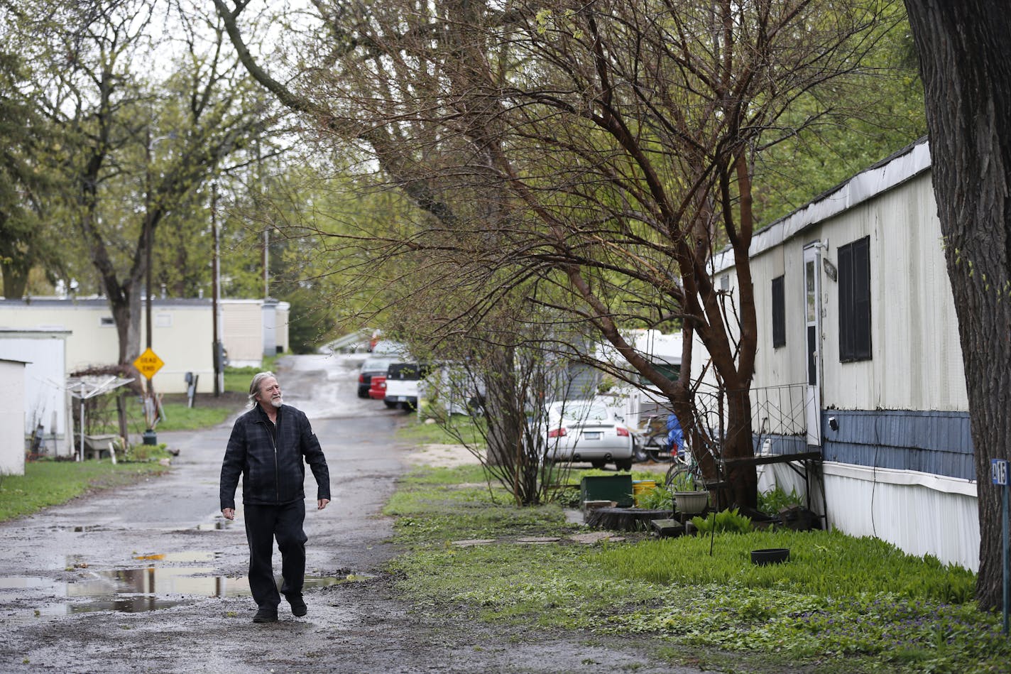 Bill McConnell walks through Lowry Grove. ] (Leila Navidi/Star Tribune) leila.navidi@startribune.com BACKGROUND INFORMATION: Thursday, April 28, 2016. Bill McConnell has lived in his manufactured home at Lowry Grove for 31 years.