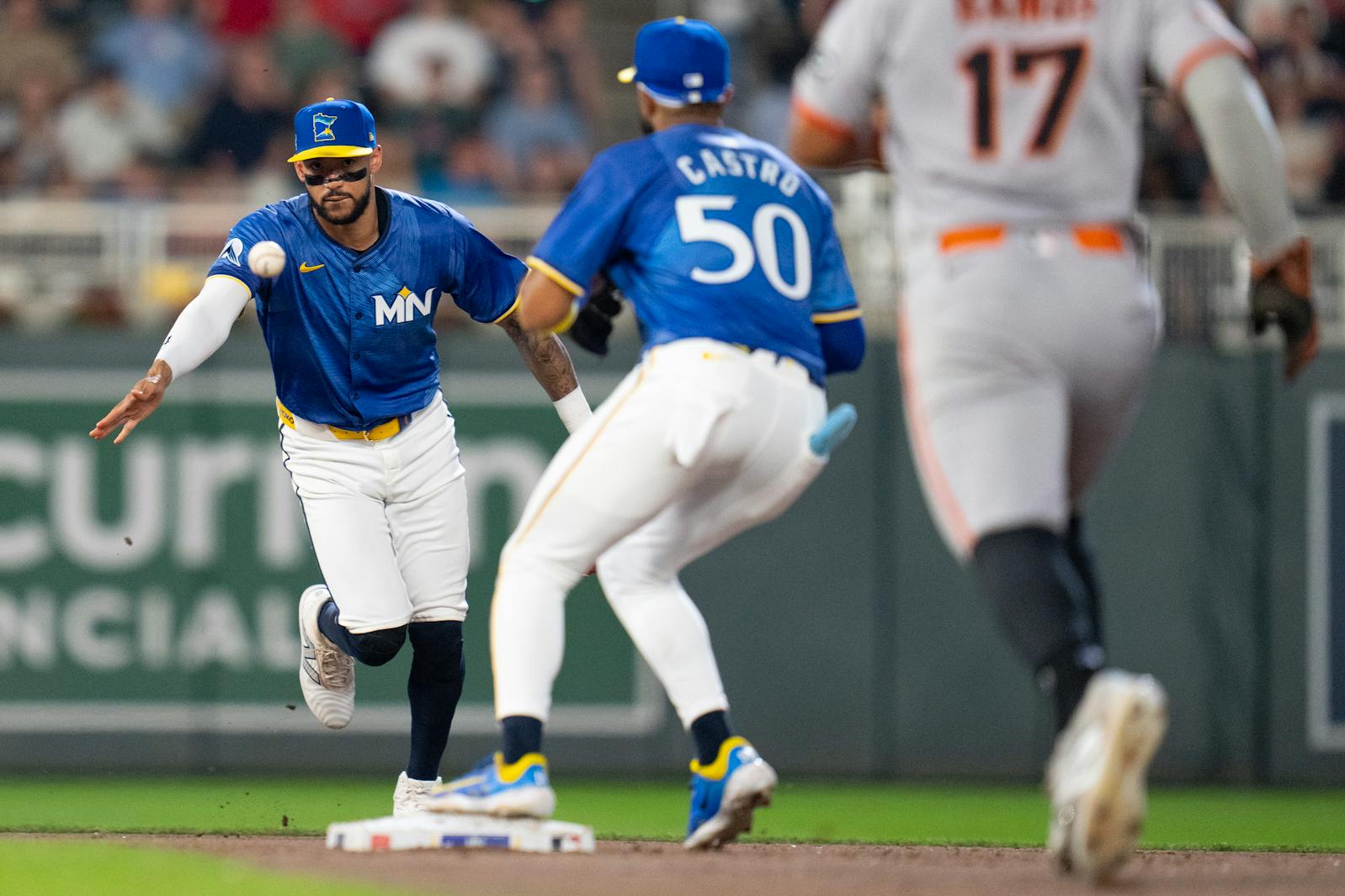 Twins shortstop Carlos Correa (4) tosses a ground ball to right fielder Willi Castro (50) for the force out on San Francisco Giants left fielder Heliot Ramos (17) during their game at Target Field on Friday, May 9, 2025.  