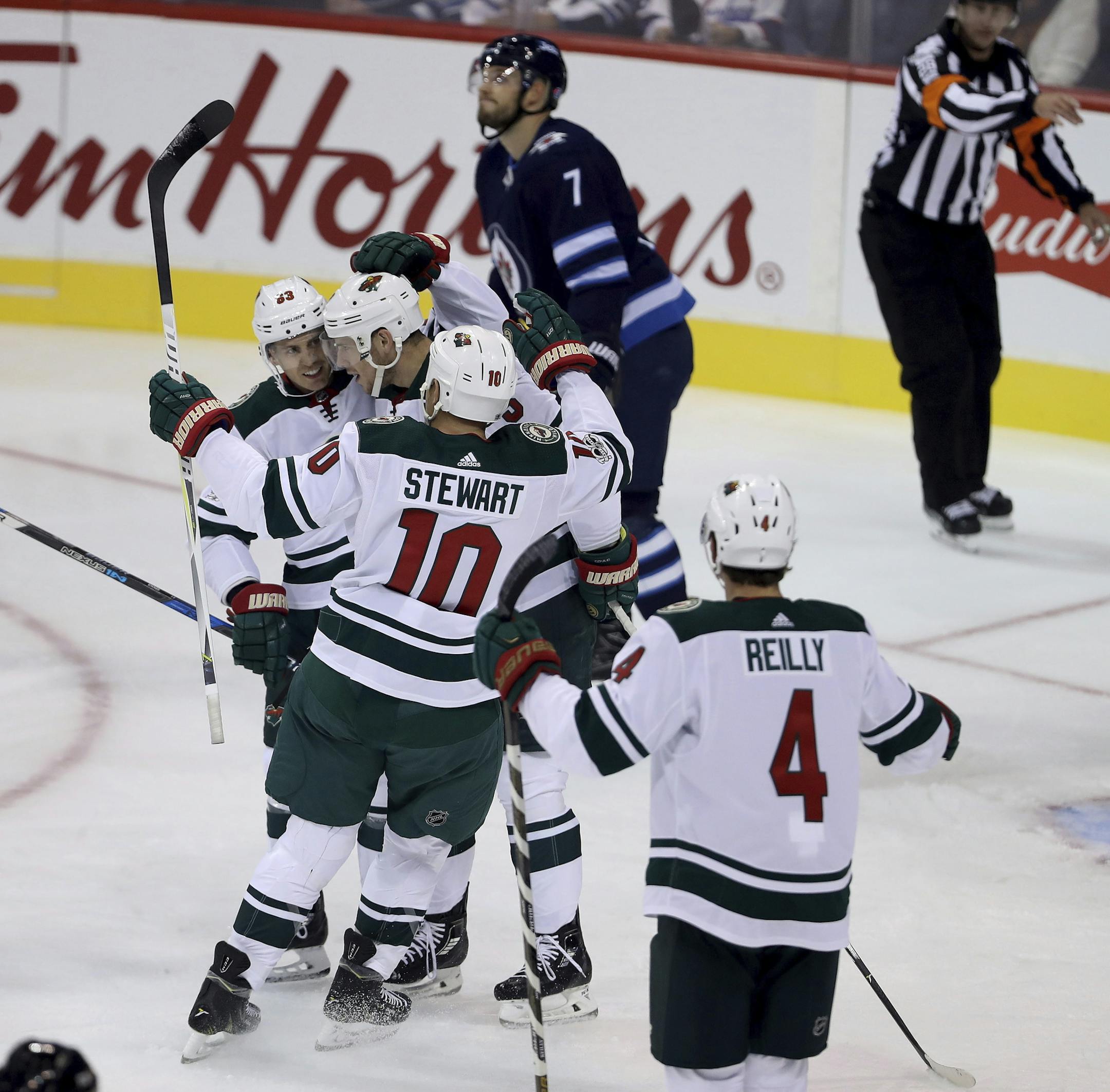 Minnesota Wild forward Tyler Ennis (63), forward Charlie Coyle (3), forward Chris Stewart (10) and defenceman Mike Reilly (4) celebrate after Coyle scored against the Winnipeg Jets during first period NHL preseason hockey action in Winnipeg, Monday, Sept. 18, 2017. (Trevor Hagan/The Canadian Press via AP)