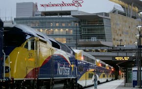 BNSF engineer Ken Devine, center, walked from the rear to the engine car of a Northstar commuter train to make a return trip to Big Lake from Target F
