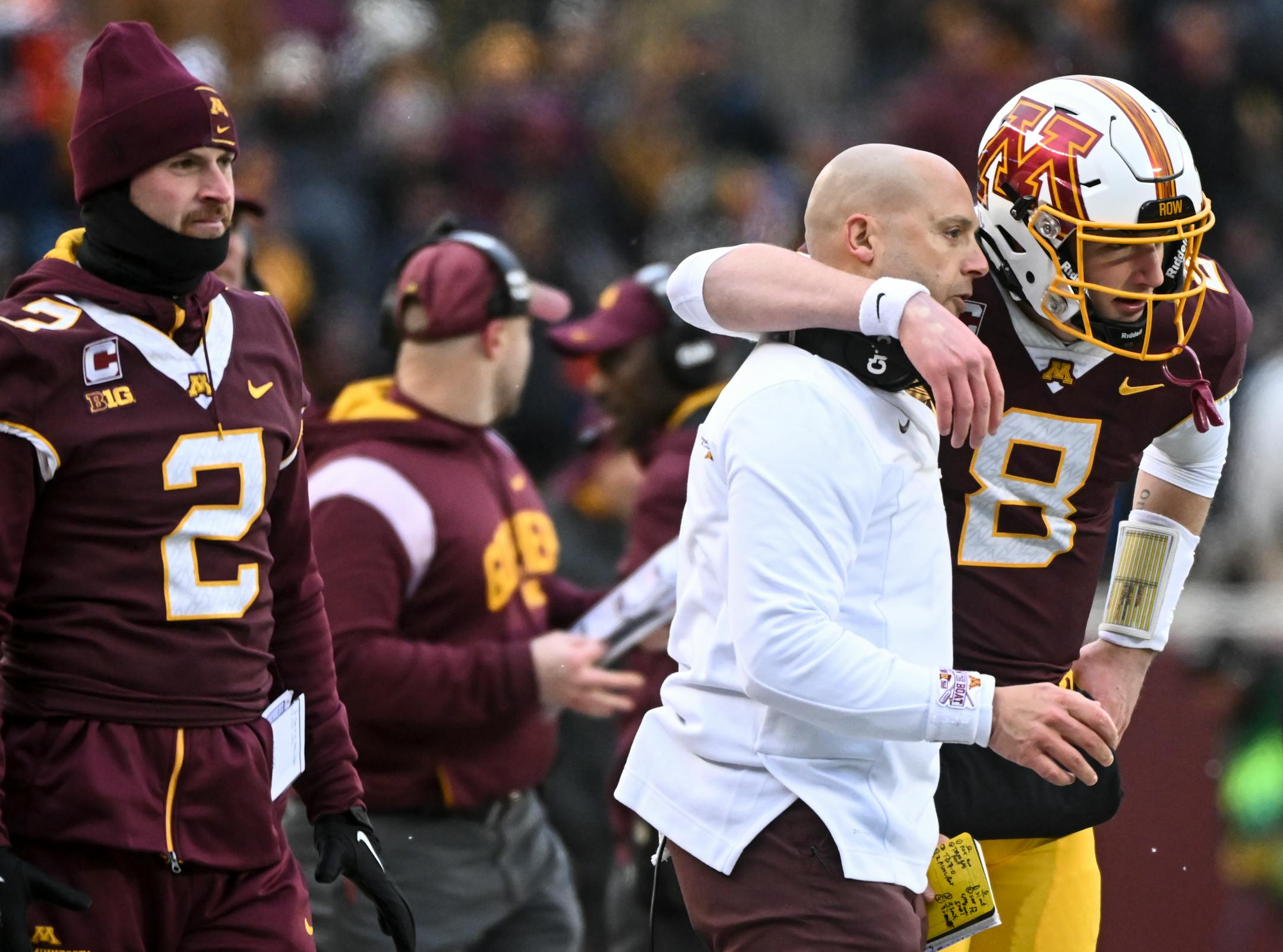 Minnesota Gophers head coach P.J. Fleck talks things over with quarterback Athan Kaliakmanis (8) after a touchdown during the first half.