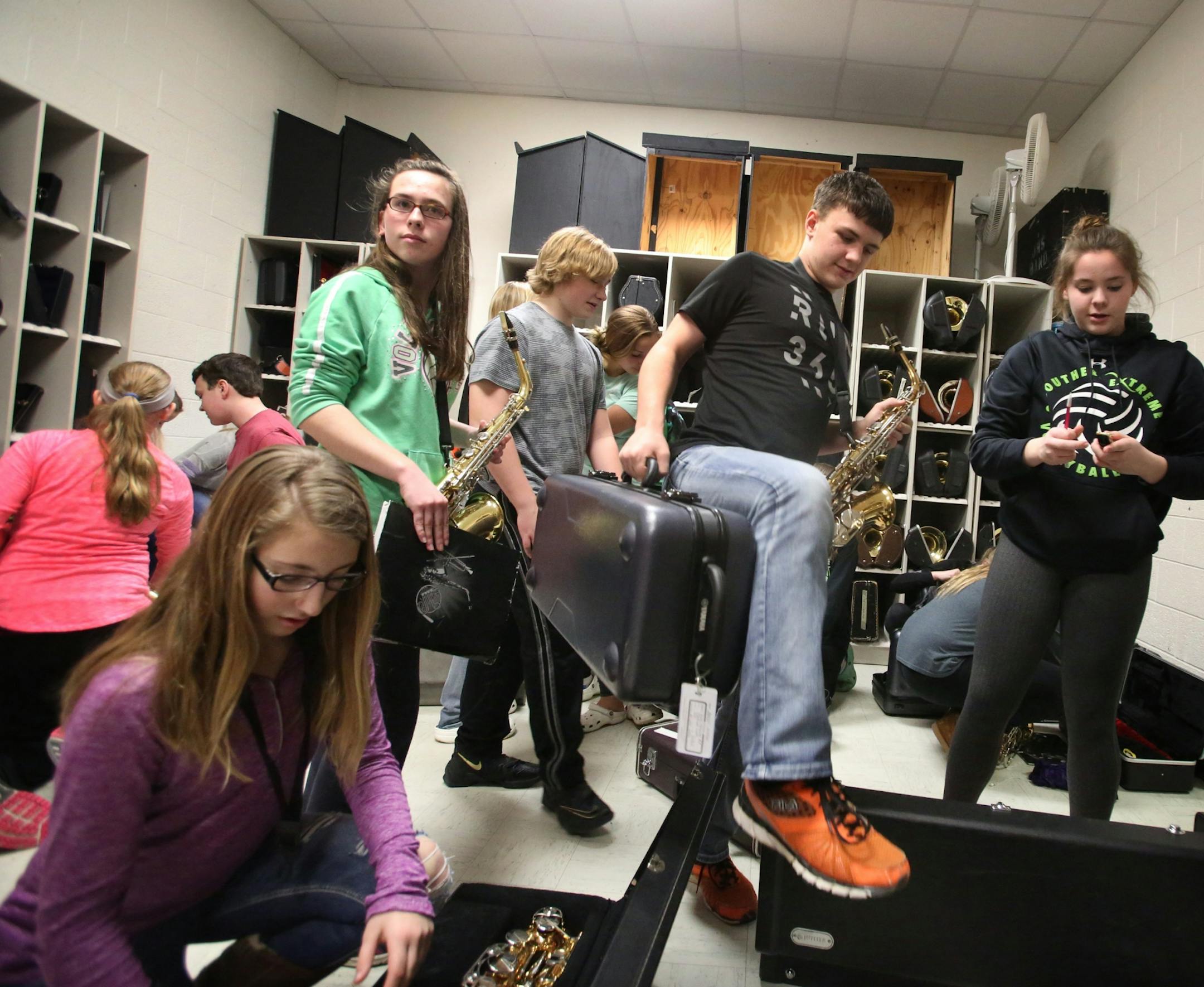 Following 7th and 8th grade band practice at Cleveland Public School, where almost 90 percent of the school's students play in band, students crowd the band closet while stowing instruments Tuesday, Feb. 21, 20117, in Cleveland, MN.