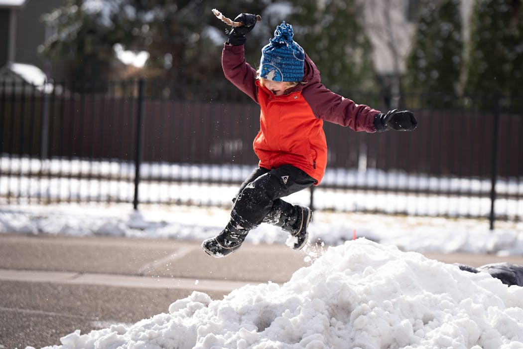 Clayton, 6, jumped and played in a pile of snow in front of their home on Friday in Apple Valley.