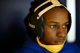 Nari Miller watches her teammates wrestle before her own match Friday, Feb. 4, 2022 at Edison High School in Minneapolis, Minn. 