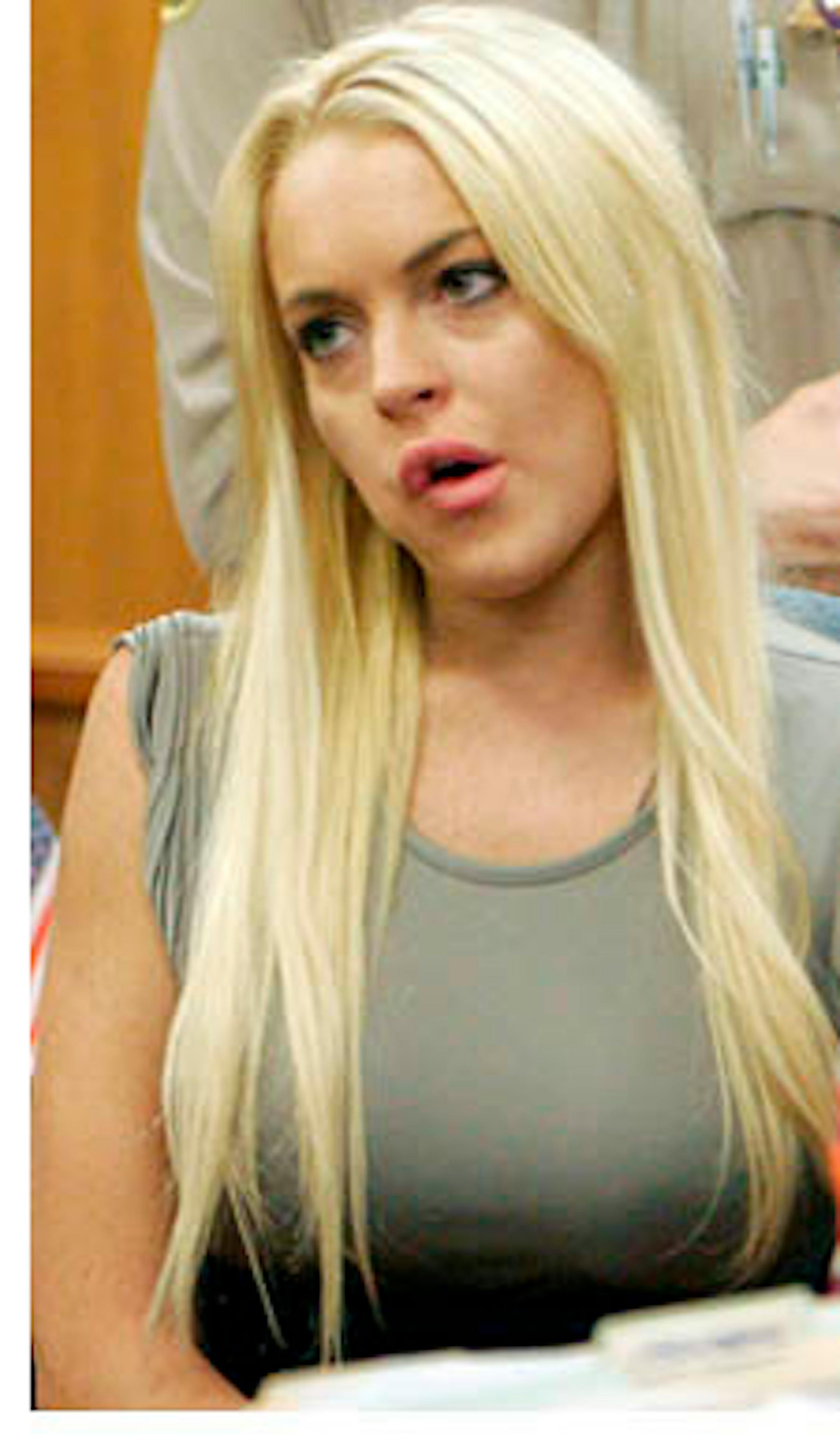 Lindsay Lohan, left, is shown in a court with her attorney Shawn Chapman Holley, Tuesday, July 20, 2010, in Beverly Hills, Calif., where Lohan was taken into custody to serve a jail sentence for probation violation. (AP Photo/Al Seib, pool)  ORG XMIT: CAKJ105