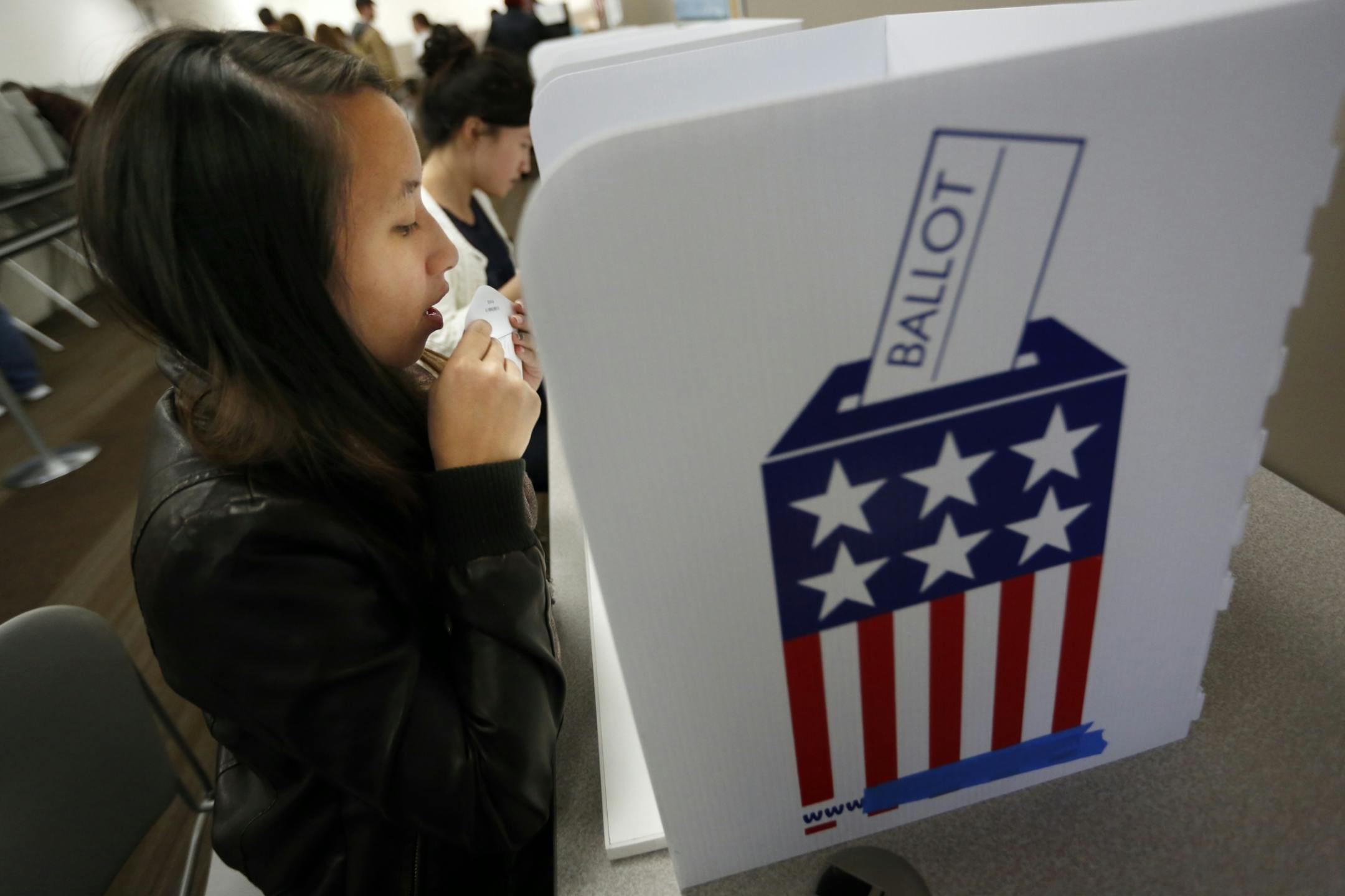 During early absentee voting at Ramsey County election headquarters, Nou Cheng,20, sealed her voting ballot including the first presidential ballot she would have cast in her lifetime.