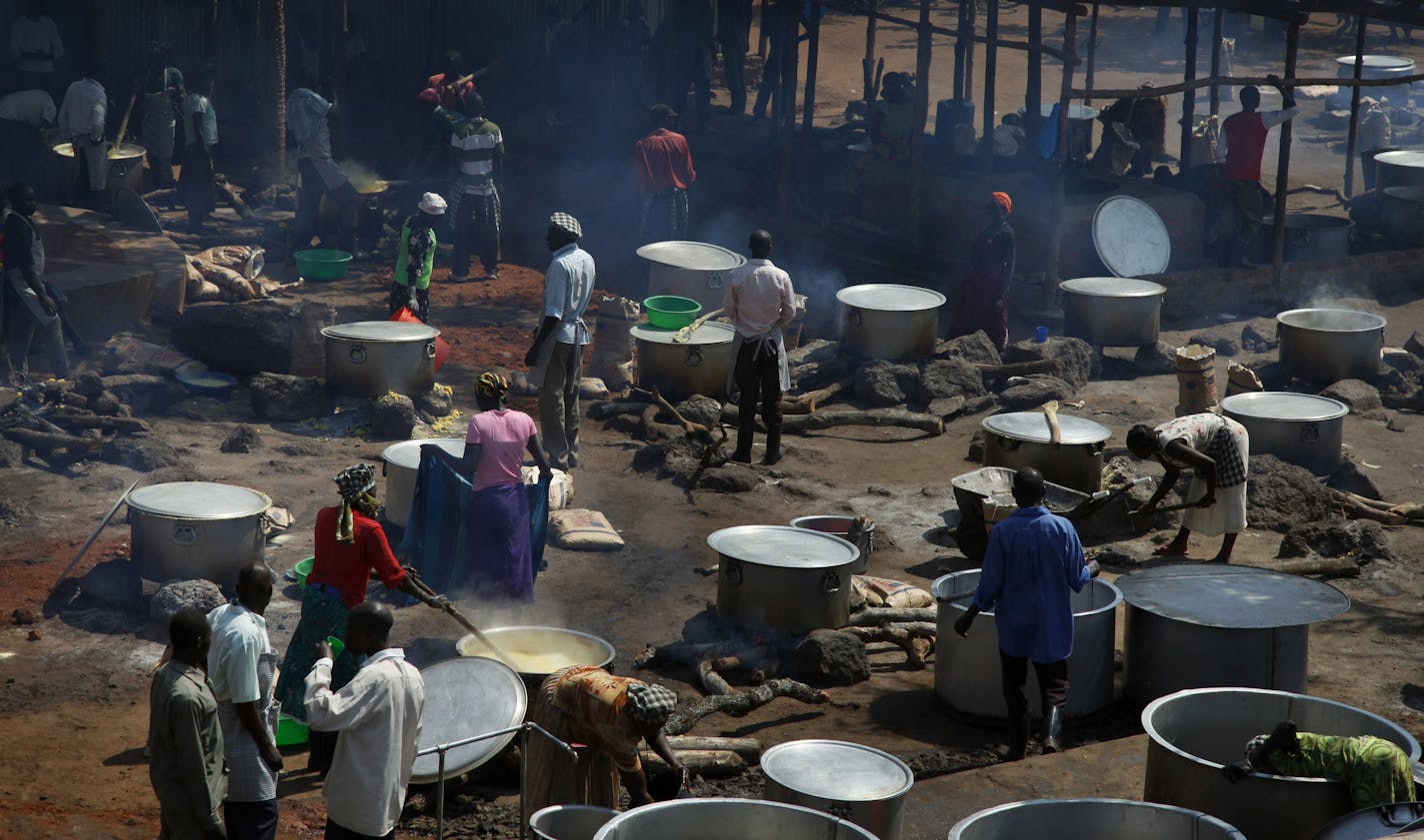 FILE - In this Monday, Aug. 29, 2016 file photo, refugees prepare food including maize porridge donated by USAID and known locally as posho, during the visit of U.N. High Commissioner for Refugees Filippo Grandi to a transit center for South Sudanese refugees in the remote northwestern district of Adjumani, near the border with South Sudan, in Uganda.