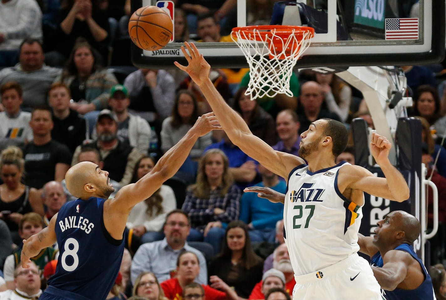 Minnesota Timberwolves guard Jerryd Bayless (8) and Utah Jazz center Rudy Gobert (27) reach for a loose ball during the first half of an NBA basketball game Friday, Jan. 25, 2019, in Salt Lake City. (AP Photo/Rick Bowmer)