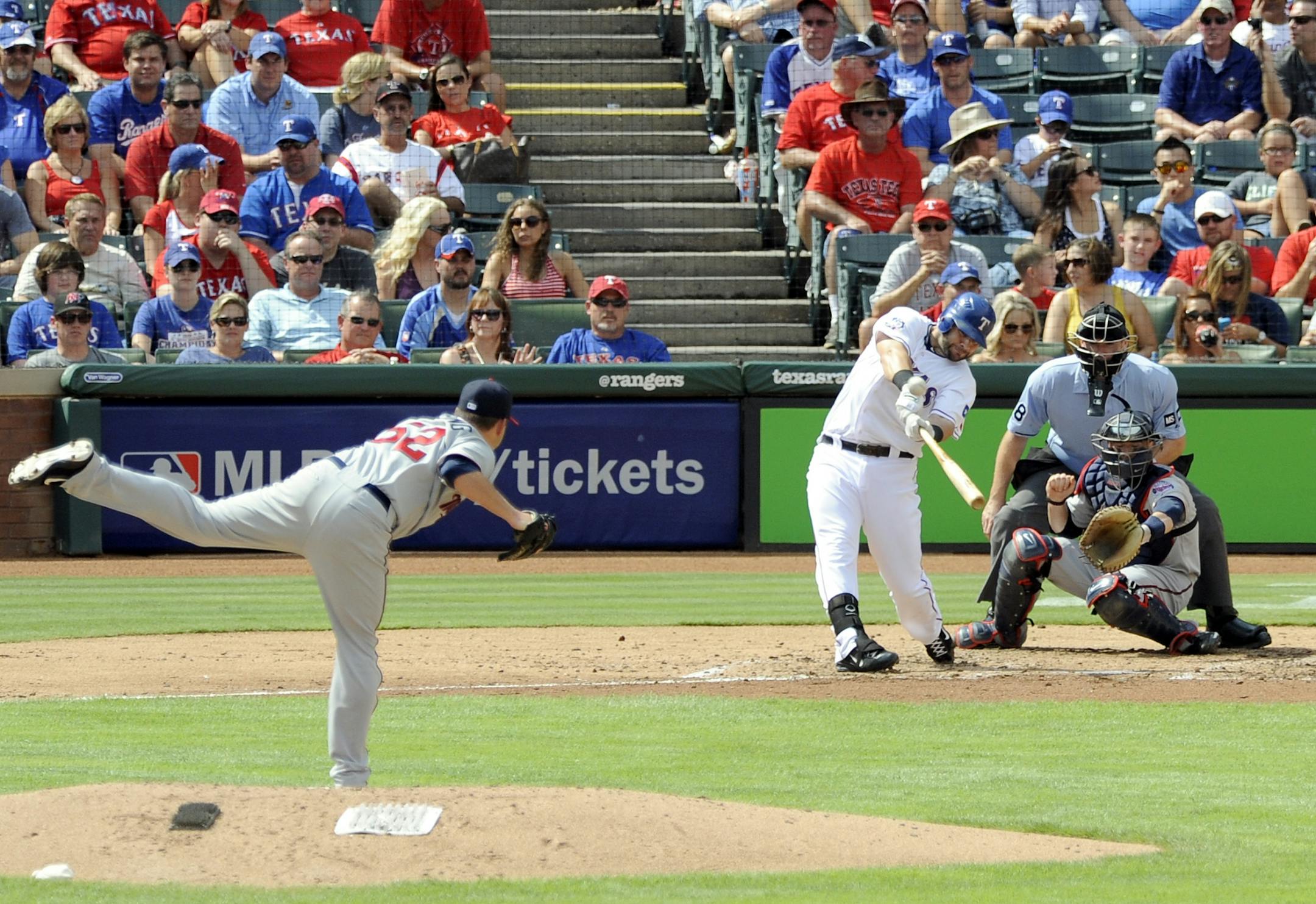 Texas Rangers' Mitch Moreland, third from right, connects for a three-run home run off Minnesota Twins starting pitcher Brian Duensing (52) in the second inning of a baseball game o Saturday, Aug. 25, 2012, in Arlington, Texas.