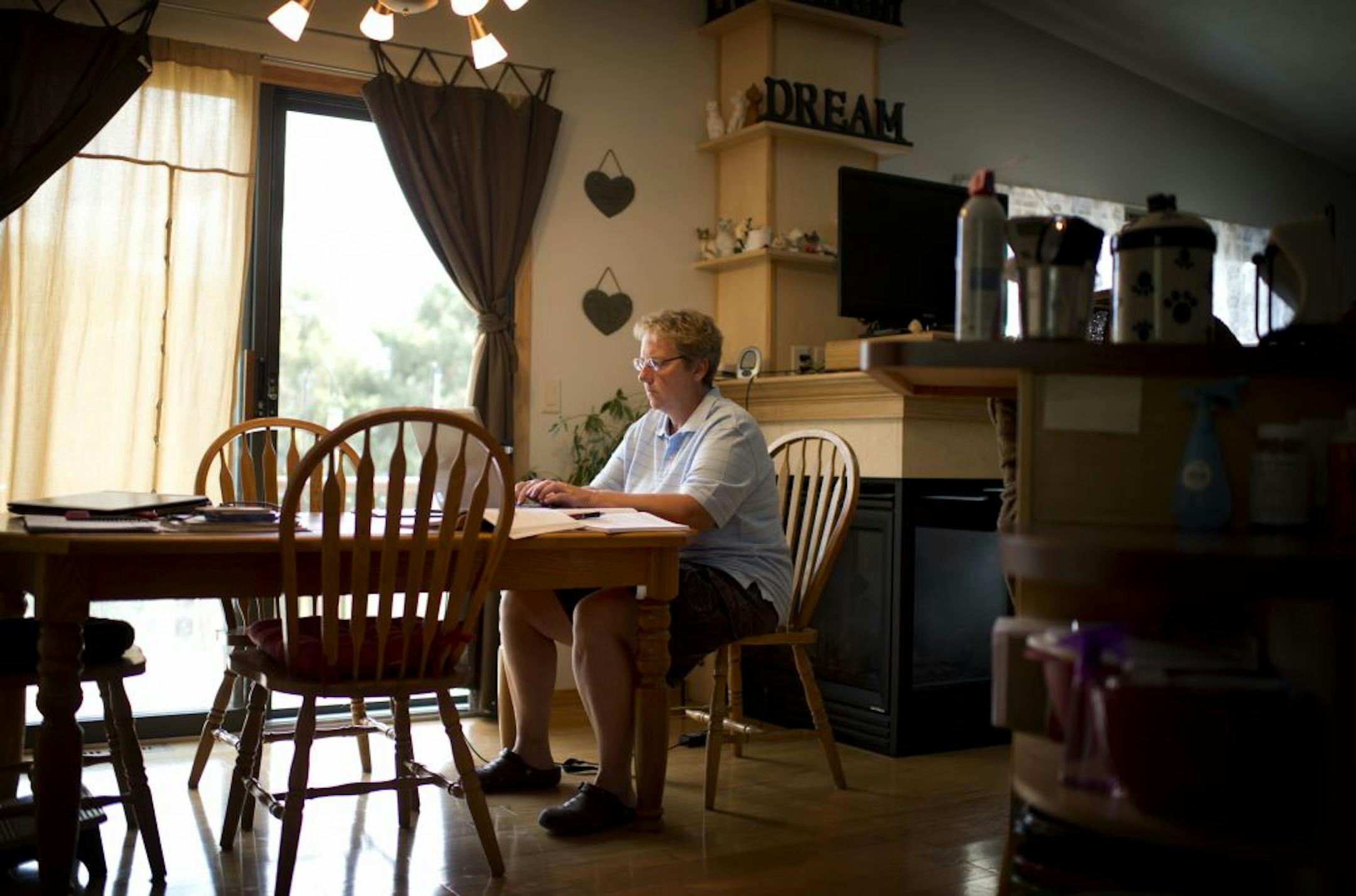 Janice Aanenson graded some papers at home for one of three part-time jobs she holds after being laid off as a college administrator.