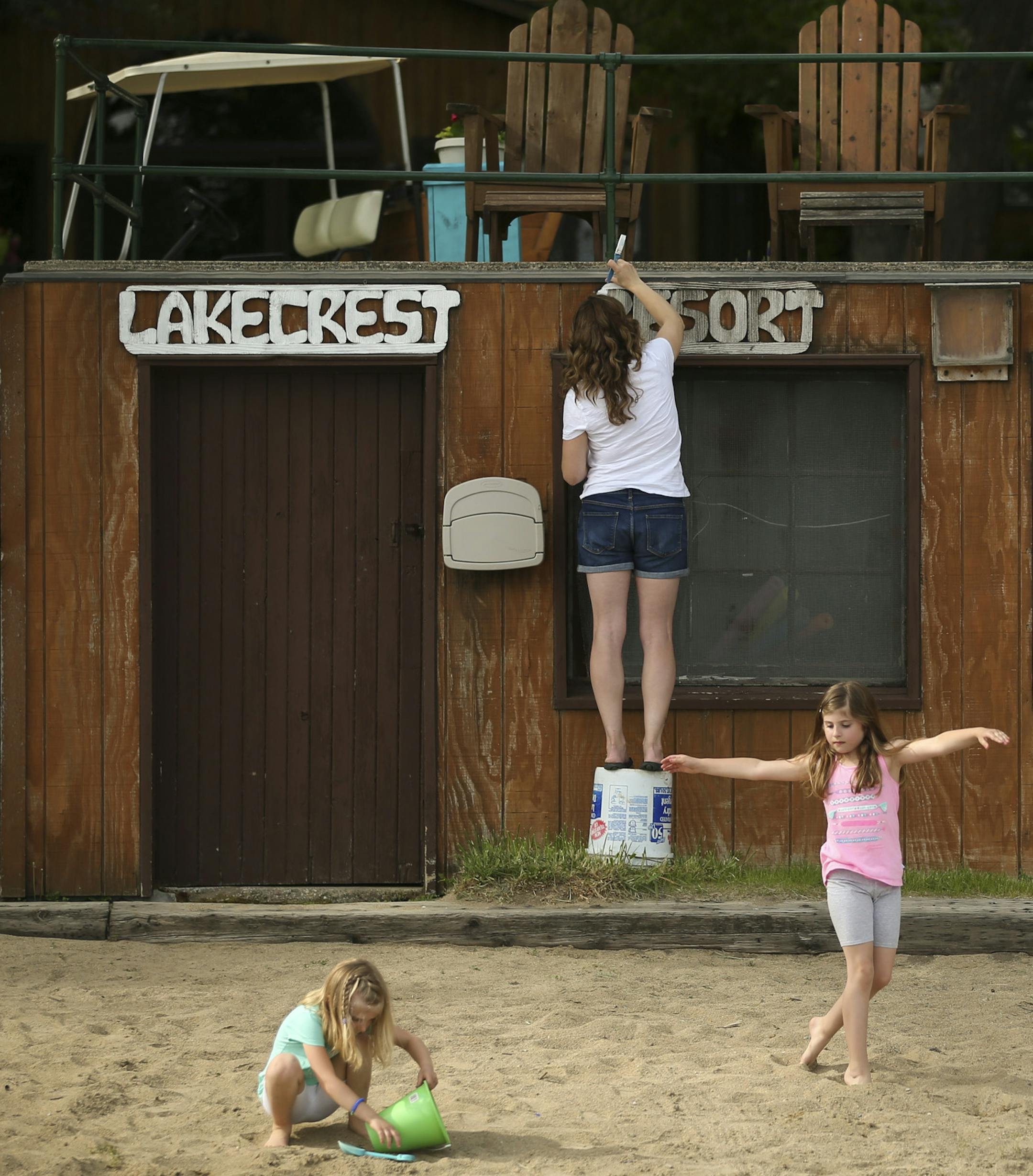 While their mother, Amy Wolf, painted a sign on a Lakecrest Resort storage shed, Ashlyn, 5, and Isabelle, 7, played nearby on the beach of the resort their family owns Monday evening. ] JEFF WHEELER &#x2022; jeff.wheeler@startribune.com Amy Wolf and her husband, Kregg, bought Lakecrest Resort on Long Lake in Detroit Lakes in January and are preparing for their first summer season as resort owners. With just a few days before the summer season kicks off, they finished getting the place ready on M