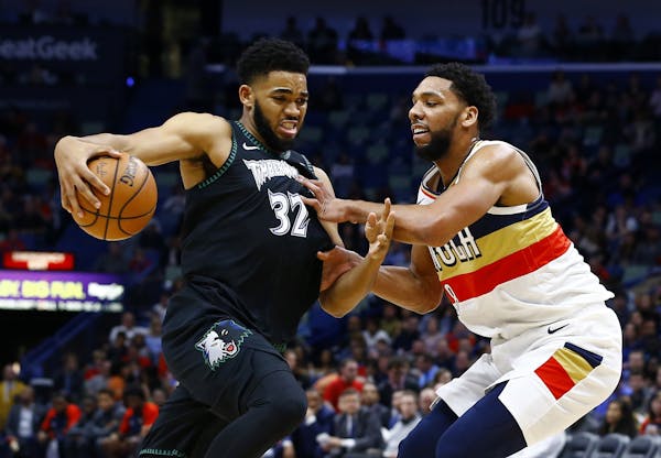 Minnesota Timberwolves center Karl-Anthony Towns (32) drives to the basket around New Orleans Pelicans center Jahlil Okafor (8) during the first half 