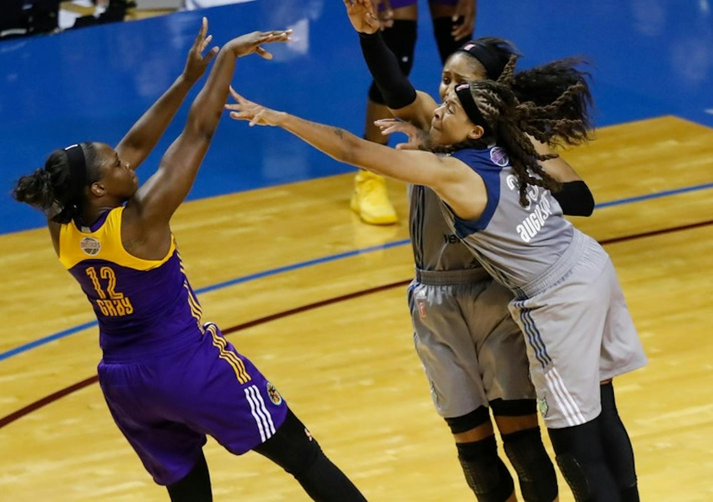 Los Angeles Sparks guard Chelsea Gray (12) shoots the game-winning shot as Minnesota Lynx forward Maya Moore (23) and guard Seimone Augustus (33) apply pressure.