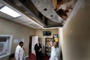 Dahir Gaban, right, stood in the mosque office where two people broke into the Islamic Center of St. Cloud and broke this ceiling panel in September 2