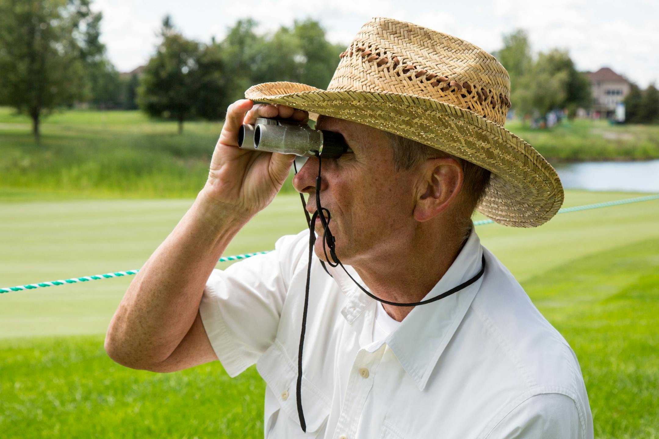 Jim O�Meara watches the third hole through his binoculars during round one of the 3M Championship at TPC Twin Cities on Friday.