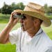 Jim O�Meara watches the third hole through his binoculars during round one of the 3M Championship at TPC Twin Cities on Friday.