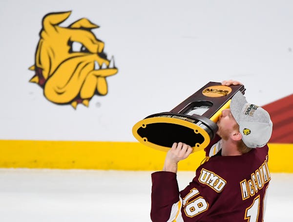 Minnesota-Duluth Bulldogs defenseman Nick McCormack (18) kissed the NCAA championship trophy while celebrating with teammates following their team's 2