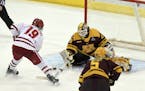 Wisconsin's Annie Pankowski (19) takes a shot on goal against Minnesota goaltender Alex Gulstene (29) during the second period in the NCAA Division I 