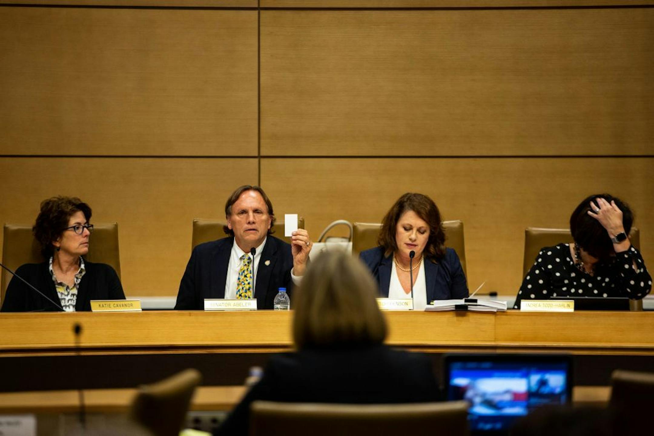 Senator Jim Abeler holds up a business card, saying that it was all the information he had gotten regarding issues in the DHS during a senate hearing about recent events in the Minnesota Department of Human Services at the Minnesota Senate Building Tuesday, August 13, 2019.
