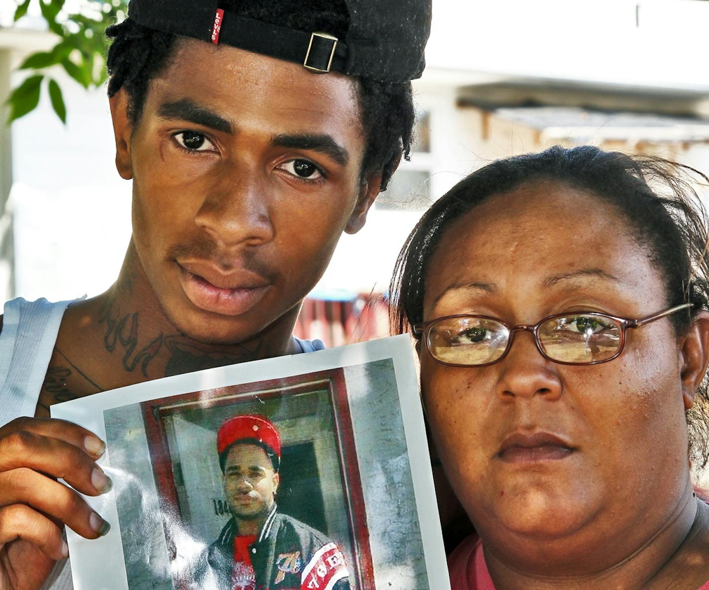 Family of Mark Eric Henderson Jr., 19, of St. Paul, who was fatally shot by police in an incident in Woodbury Friday.. Left, brother Fred Henderson, 18, and mother Tawana Henderson, both of St. Paul, held a photo of Mark Henderson Jr.