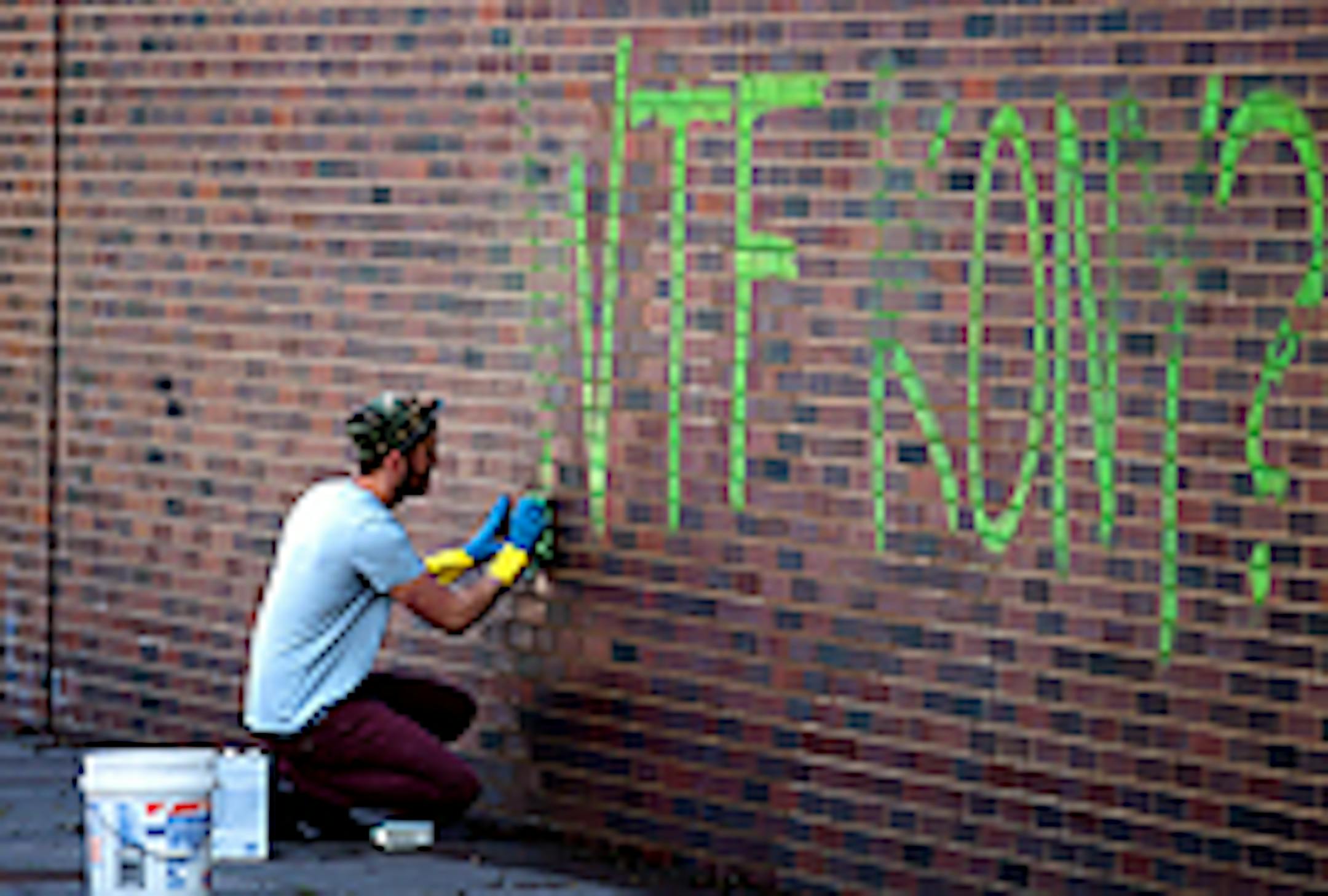 Ryan Kitchen removed graffiti from the from the brick wall at the Walker Art Center Sculpture Garden