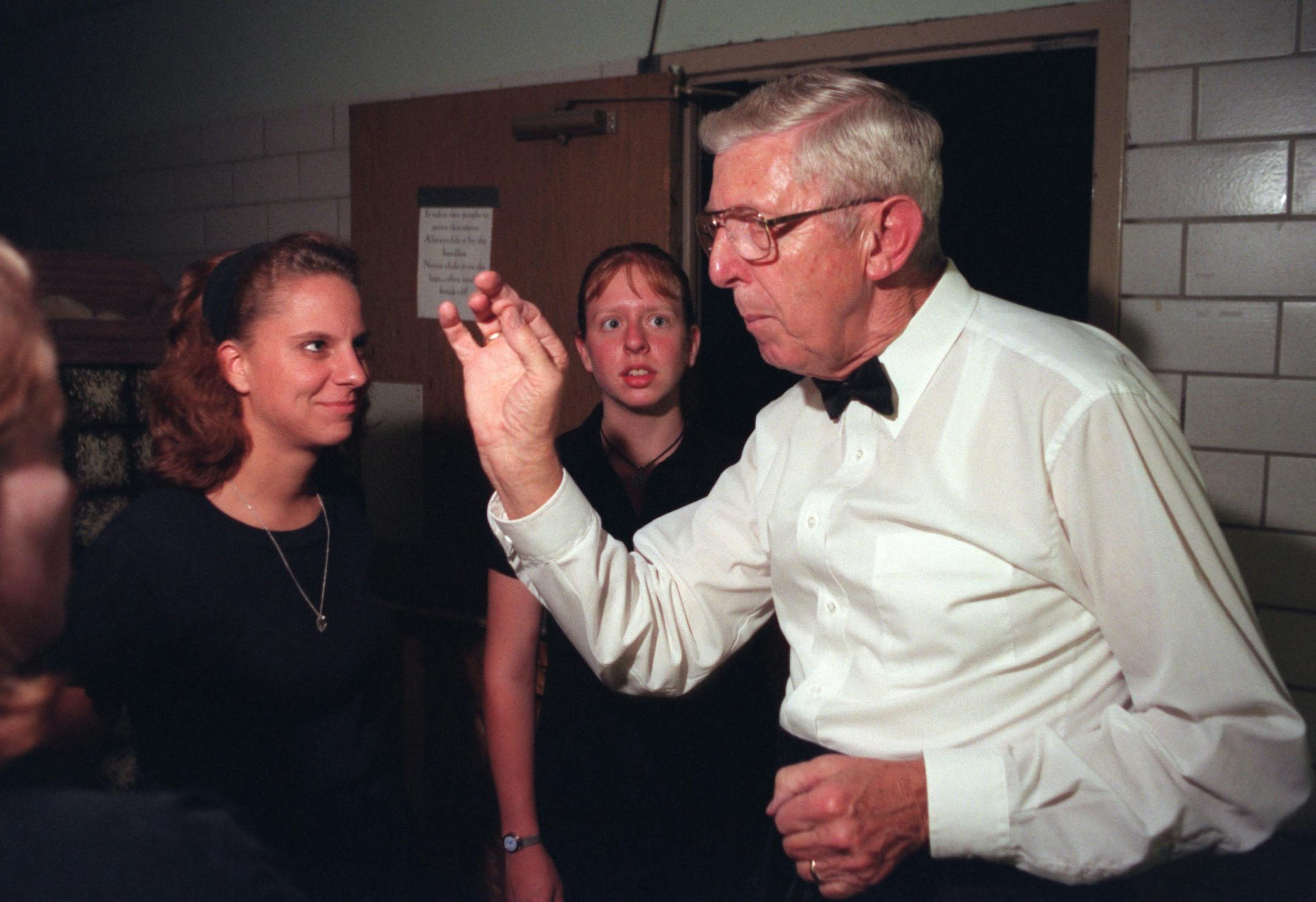 Frank Asenbrenner gives orchestra members some advice between sets during the production of Oliver at Hill Murry High SchoolÌs Pioneer Theater.