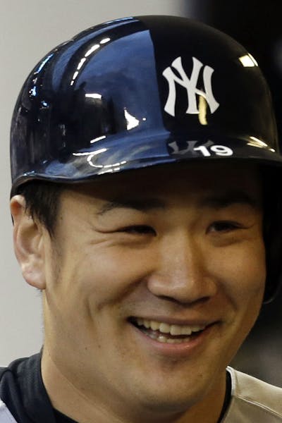 New York Yankees starting pitcher Masahiro Tanaka stands in the dugout after striking out against the Milwaukee Brewers in the third inning of a baseb