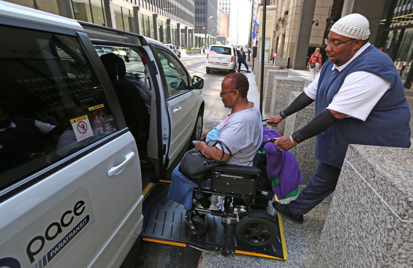 Pace driver Carl James assists Renita Freeman into his van as she leaves her job at the Ralph Metcalfe Federal Building on July 17, 2015 in Chicago. (Phil Velasquez/ Chicago Tribune/TNS)