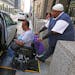Pace driver Carl James assists Renita Freeman into his van as she leaves her job at the Ralph Metcalfe Federal Building on July 17, 2015 in Chicago. (