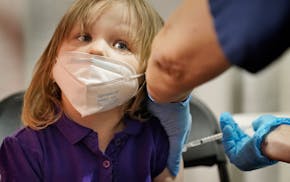 Athena Clark, 3, of Minneapolis seemed unfazed as she got her first COVID-19 vaccination from registered nurse Reva Rasmussen at the Mall of America v