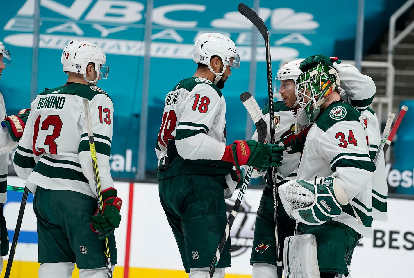 Minnesota Wild goaltender Kaapo Kahkonen (34) is congratulated by teammates after their victory over the San Jose Sharks in an NHL hockey game in San Jose, Calif., Monday, Feb. 22, 2021. (AP Photo/Tony Avelar)